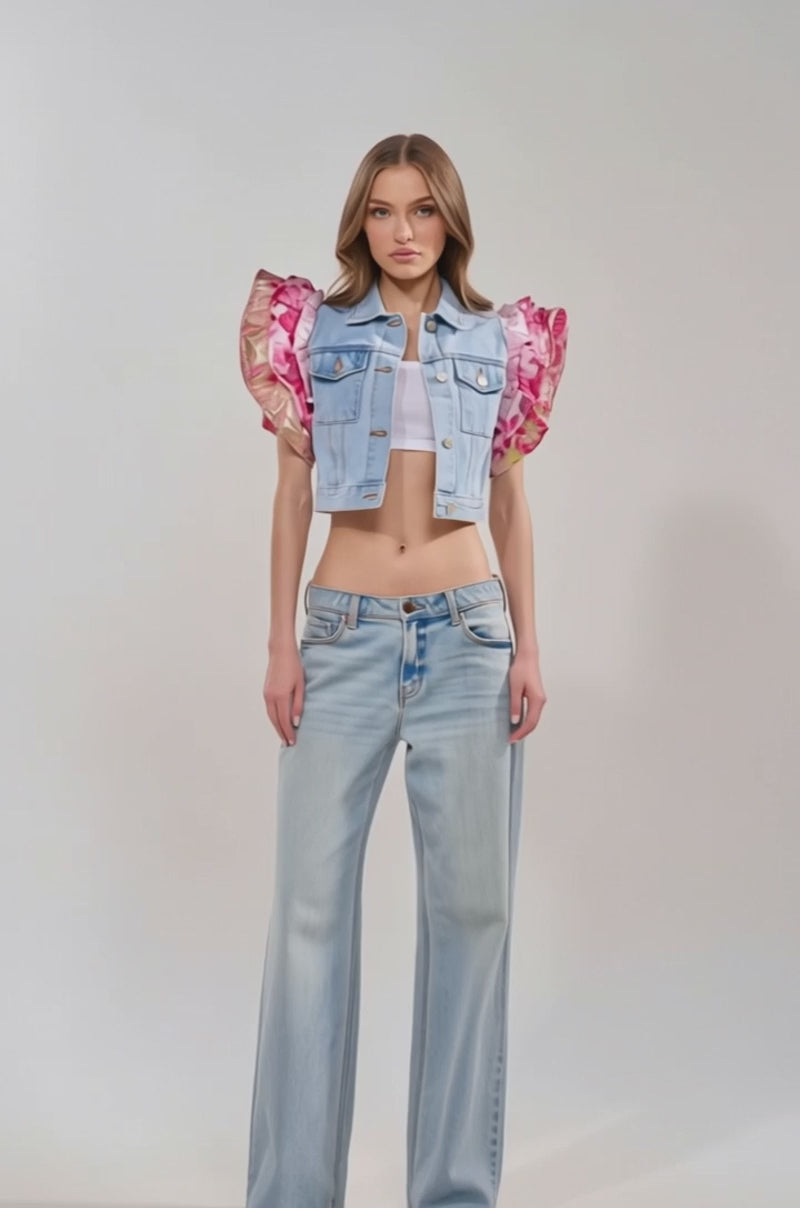 Video of woman modeling the SWEET THING DENIM VEST with brocade ruffle sleeves over a white crop top and light-wash blue jeans