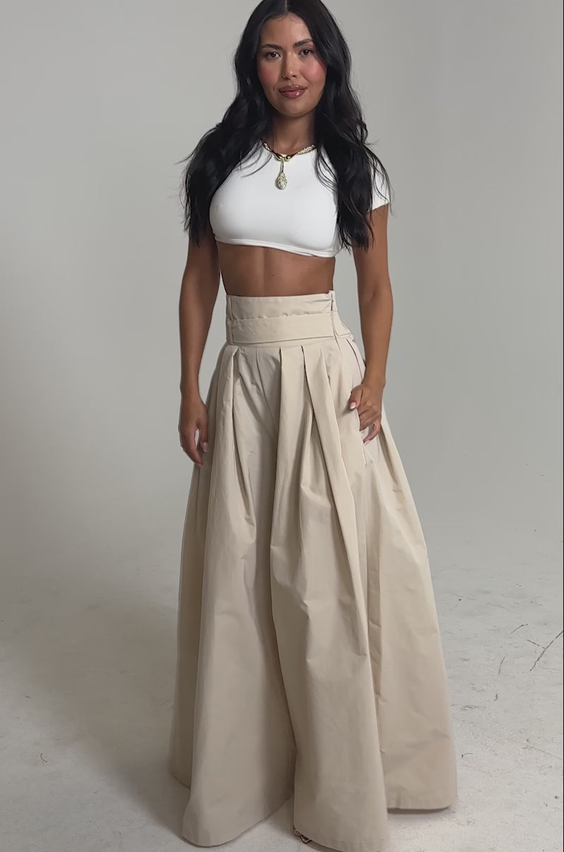 Video of woman modeling the DISCO DOLL TROUSER—beige statement pants with an ultra-wide leg and high-rise waist—paired with a white crop top.