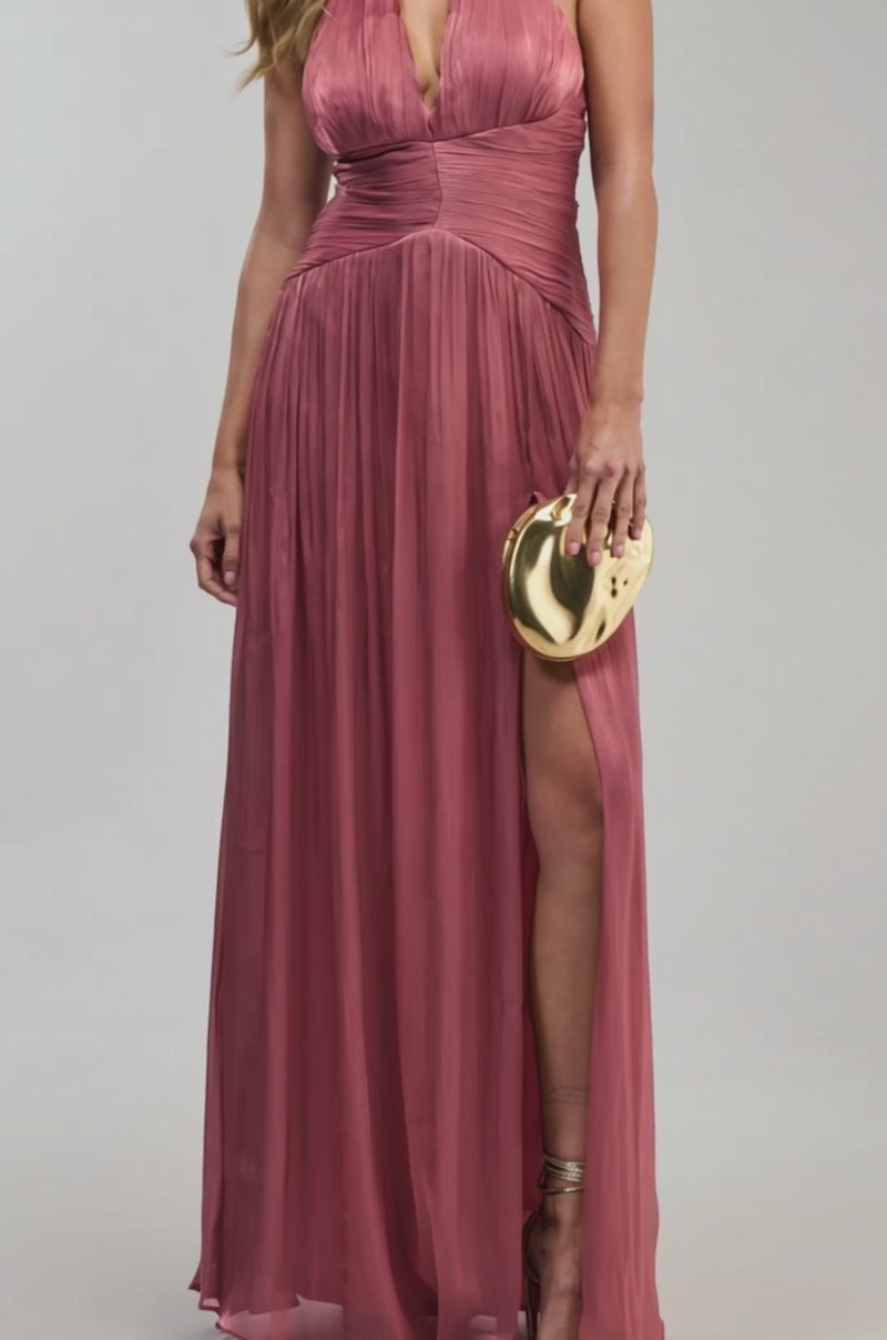 Video of a woman modeling the TOO STYLED TO CARE MAXI DRESS IN RUST, a sleeveless halter-style maxi featuring a deep v-neckline and high slit. 