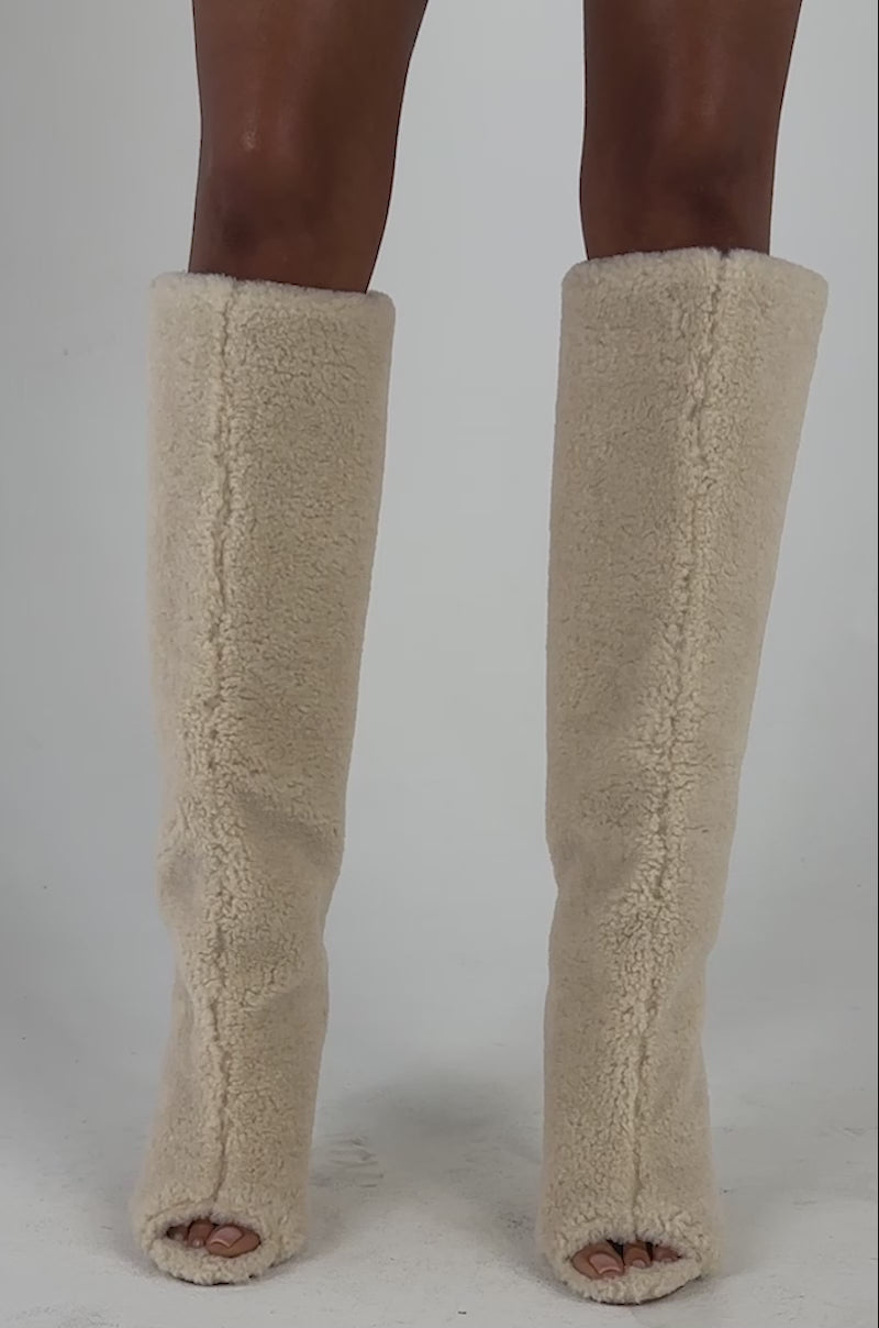 Video of a woman modeling the AKIRA GOLD VINCENT SHERPA IVORY OPEN TOE WEDGE BOOT.