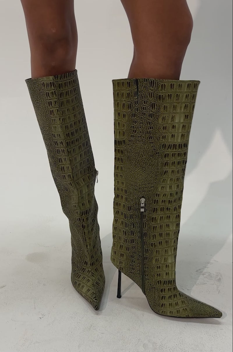 Video of a woman modeling the AZALEA WANG MADEYE OLIVE CROC STILETTO BOOT—striking knee-high stiletto boots with pointed toes, crafted from croc-embossed faux leather in a bold green hue.