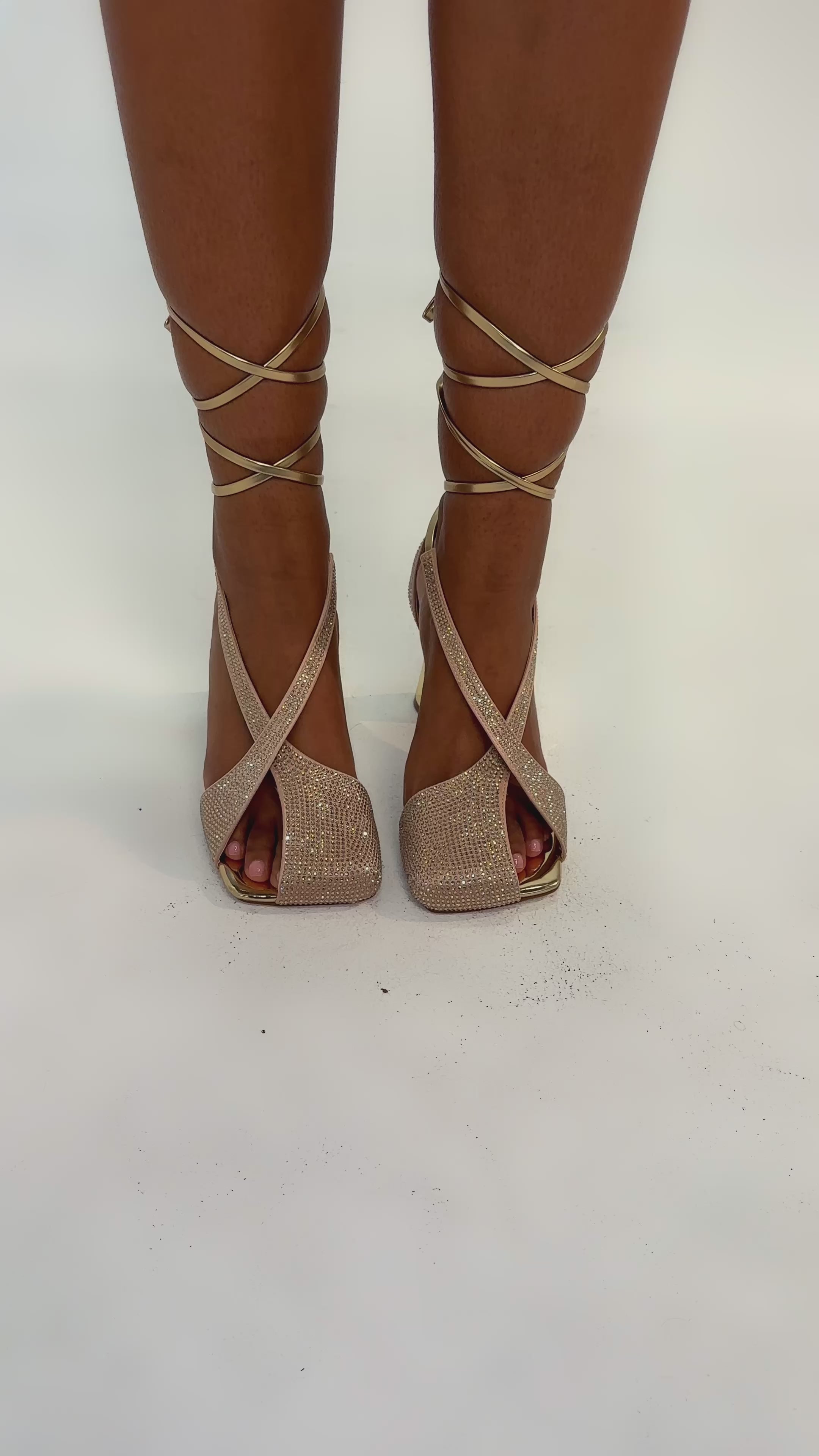 Video of woman modeling the AZALEA WANG BUILANY GOLD RHINESTONE CHUNKY PUMP with sparkly criss-cross straps and thick metallic gold heels