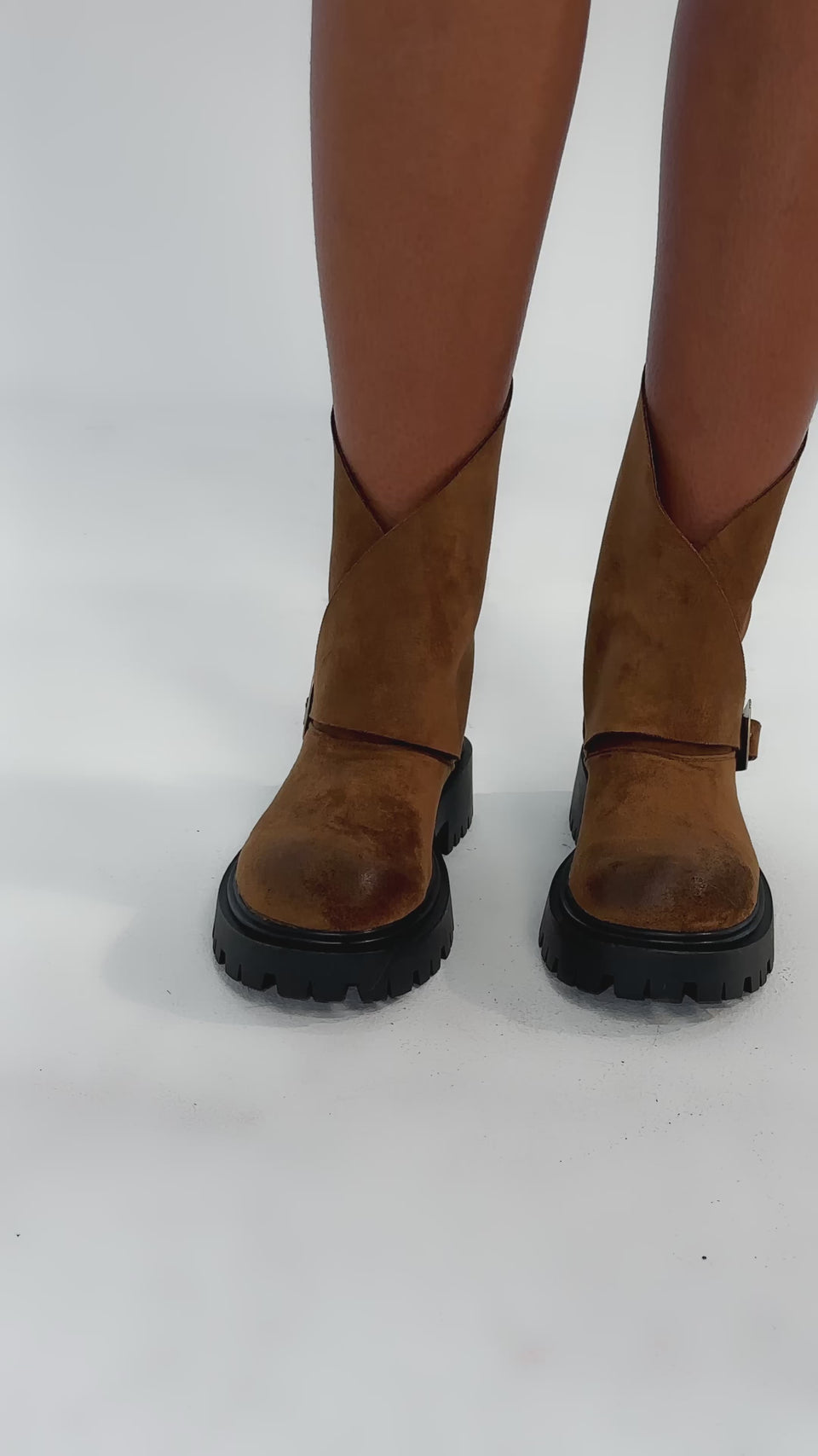 Video of woman modeling the AZALEA WANG PHRIXUS Brown Chunky Short Shaft Faux Suede Boot, featuring chunky black soles and a gold buckle detail.