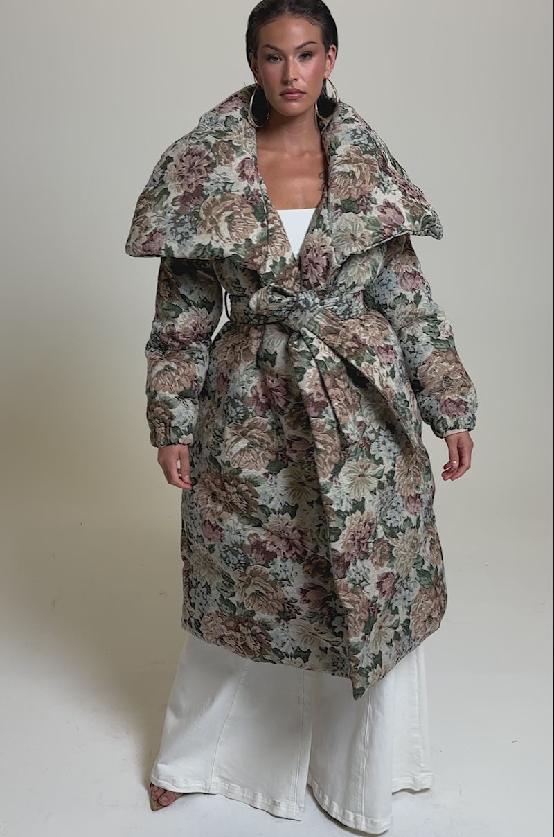 A video of a woman wearing the I'M OUTSIDE TAPESTRY PUFFER over a white top and cream-colored wide-leg pants.