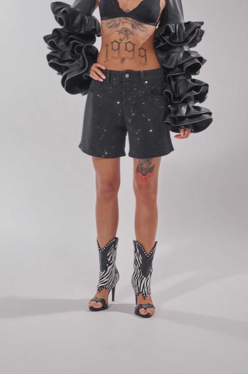 Video of woman modeling the HAILEY EMBELLISHED SHORT, frilled black sleeves and open-toe zebra cowboy boots