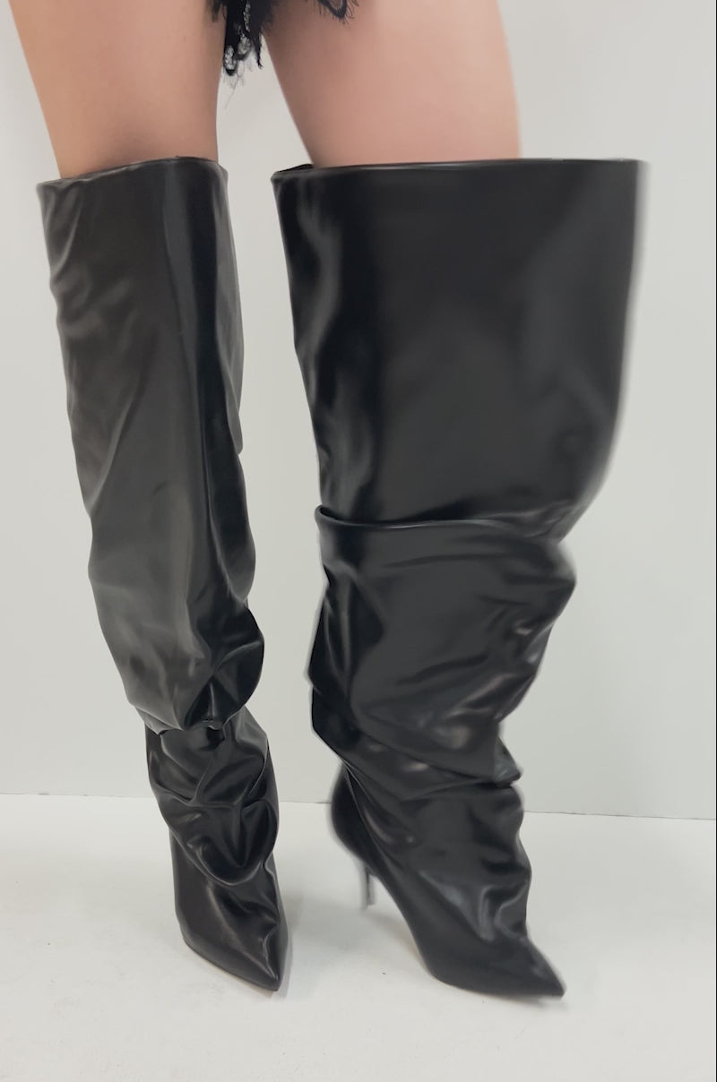 Video of person  against a plain white background, showcasing the AZALEA WANG RUBIUS BLACK EXTREME RUCHED BOOT with stiletto heels.