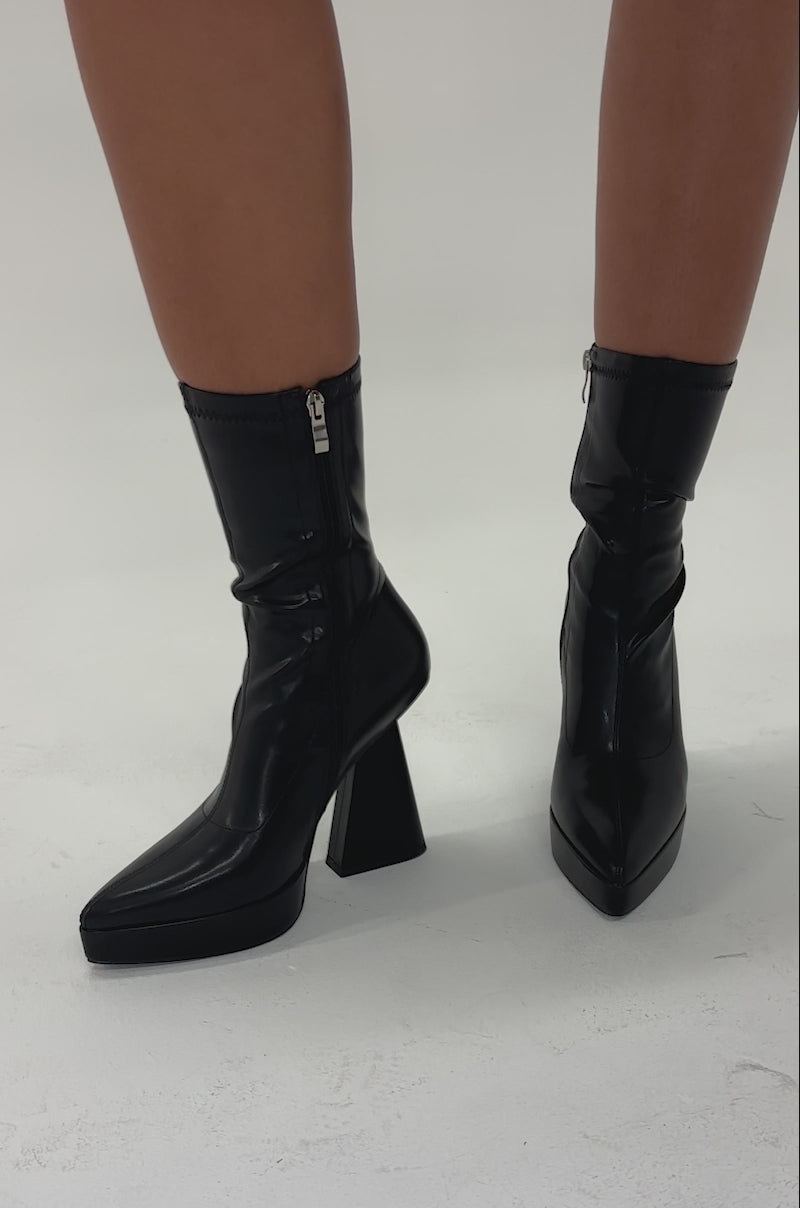 Video of woman modeling the AZALEA WANG SAXTON BLACK PU CHUNKY POINTED TOE BOOTIE, featuring geometric chunky heels, side zippers, and a sleek, modern design.