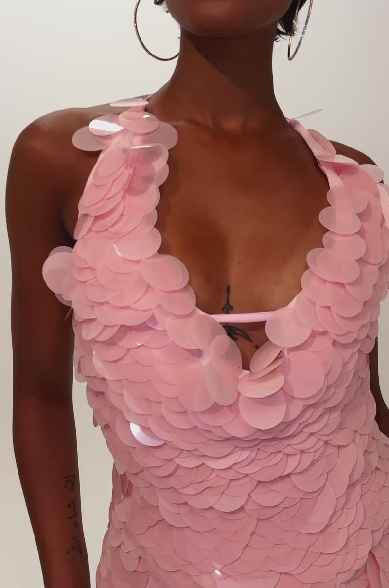 Video of woman modeling the LOVE BOMB SEQUIN MINI SKIRT, a light pink mini skirt adorned with shimmering circular sequins reminiscent of a chic party look. 