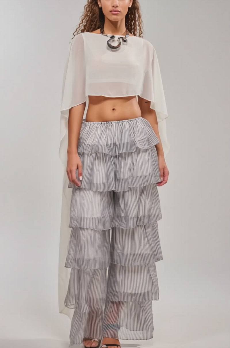 Video of woman modeling the ALL I WANT TO DO STRIPE PALAZZO PANT—high-waisted, striped, with ruffled tiers and airy fabric—with open-toed shoes and a white top for a perfect spring festival look.