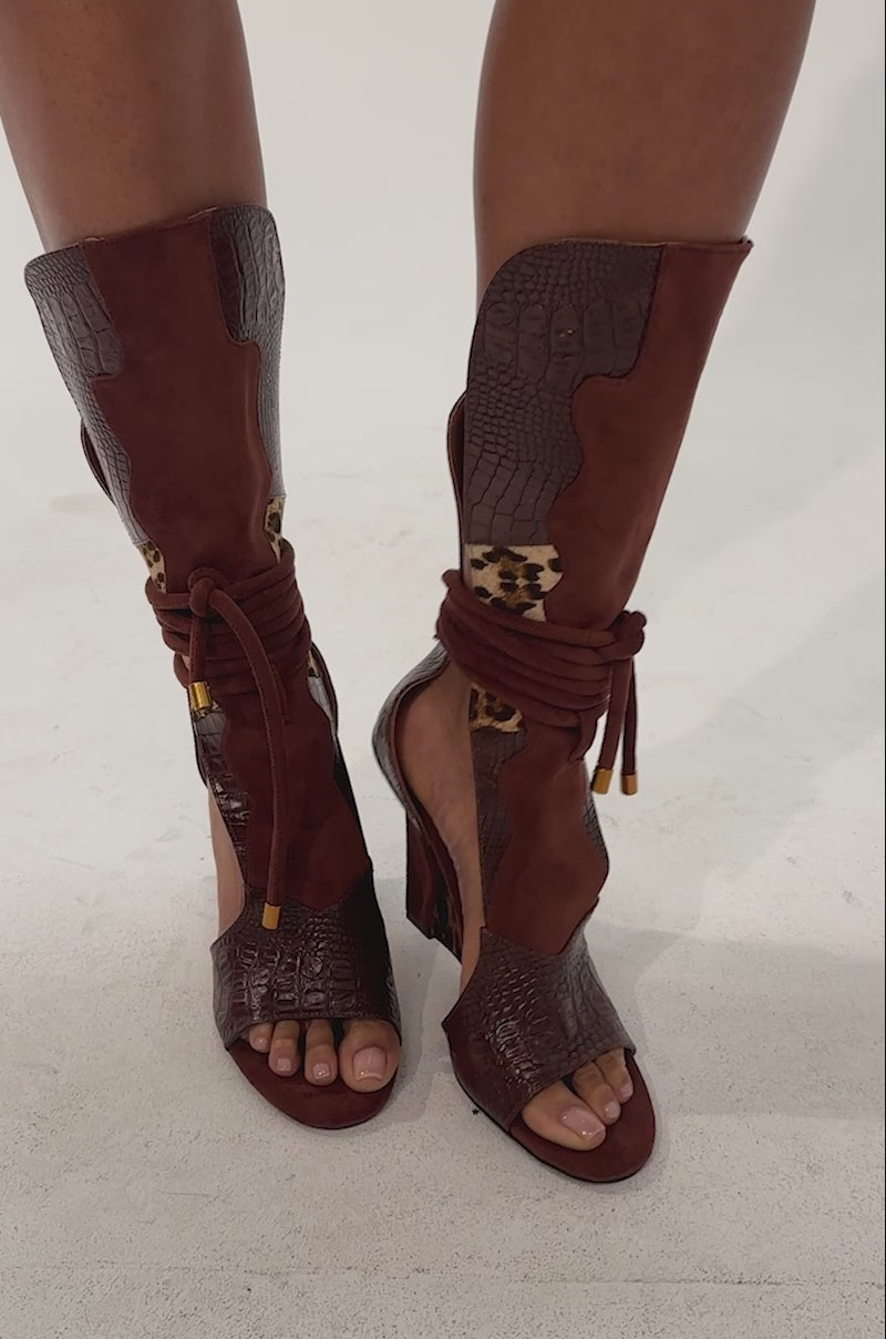 Video of a woman modeling the AZALEA WANG DESIRE BROWN MULTI WEDGE SANDAL featuring western-inspired design with brown, crocodile, and cheetah print patterns.
