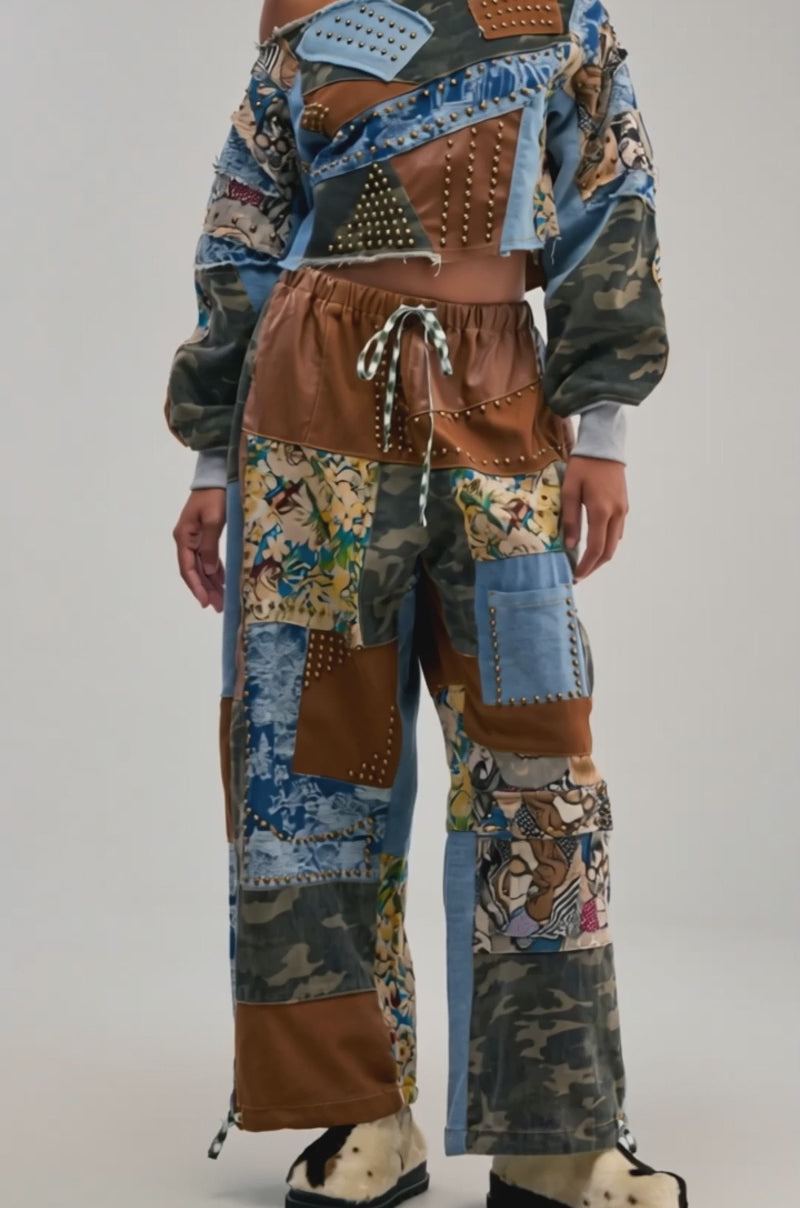 Video of a woman modeling the CALL EM CRAZY PATCHWORK JOGGER IN BROWN MULTI—an eye-catching piece ideal for fall fashion, featuring a mix of denim, camouflage, and leather-patterned fabrics for a trendy streetwear vibe. 