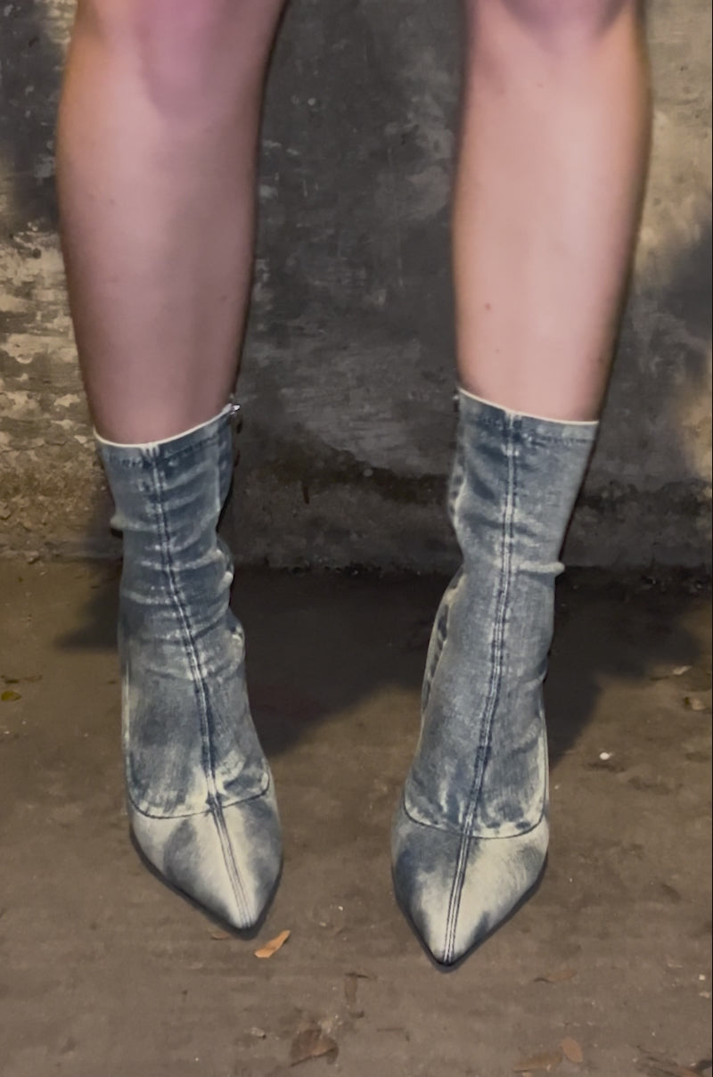 Video of person showing off the AZALEA WANG CALEANA DENIM STILETTO BOOTIE featuring an ankle-length sock fit, denim fabric, slim stiletto heel, and pointed toe design