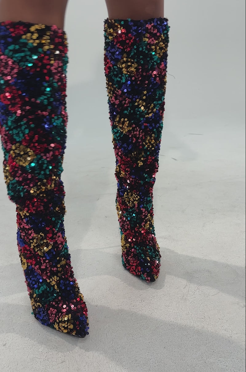 A video of a person in a burgundy blazer and AZALEA WANG JIMENA MULTI SEQUIN EMBELLISHED BOOT stands confidently against a light background.