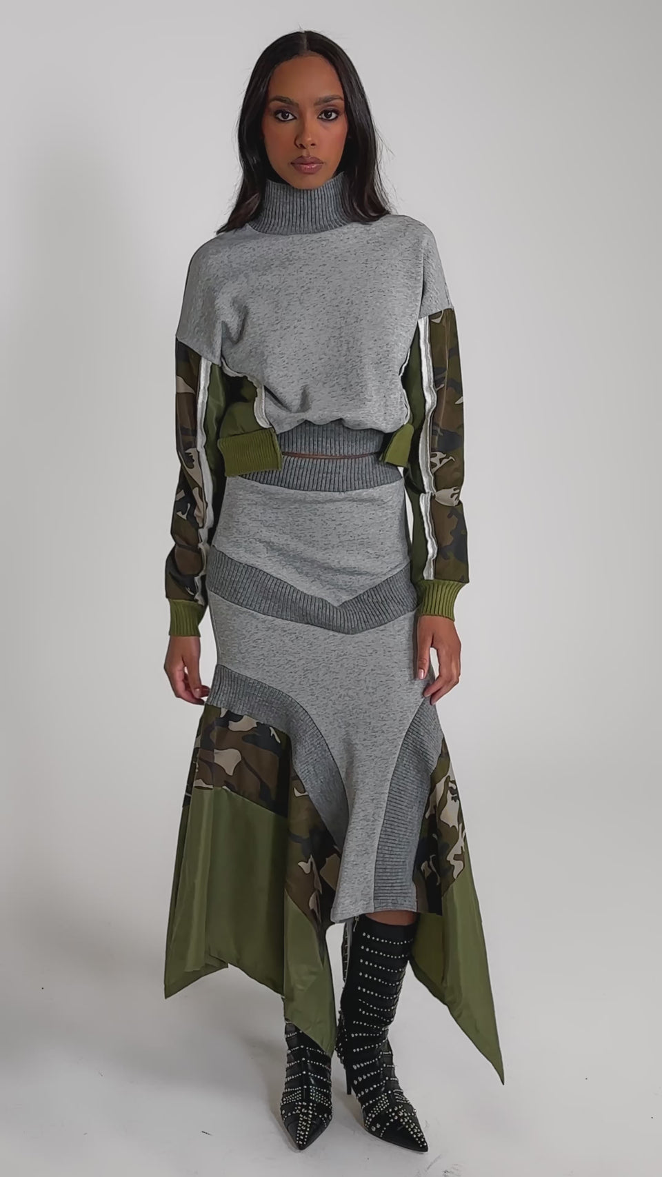 Video of woman modeling the INES COLORBLOCKED SWEATSHIRT— a grey cropped style with camouflage-patterned sleeves—paired with a matching skirt featuring camo details.