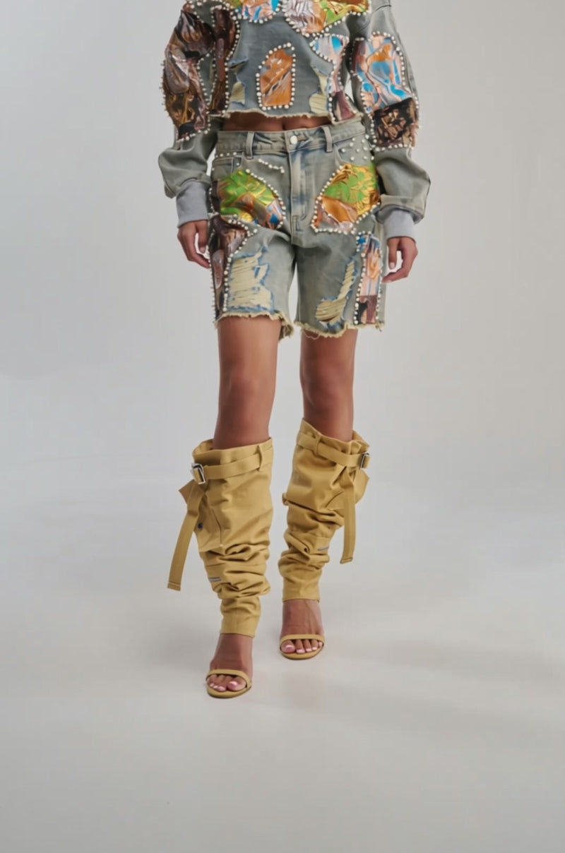 Video of woman modeling the PATCHED UP BROCADE DENIM SWEATSHIRT—a relaxed-fit, cropped denim piece with colorful patches, pearls, gold details, and frayed edges for a statement look.