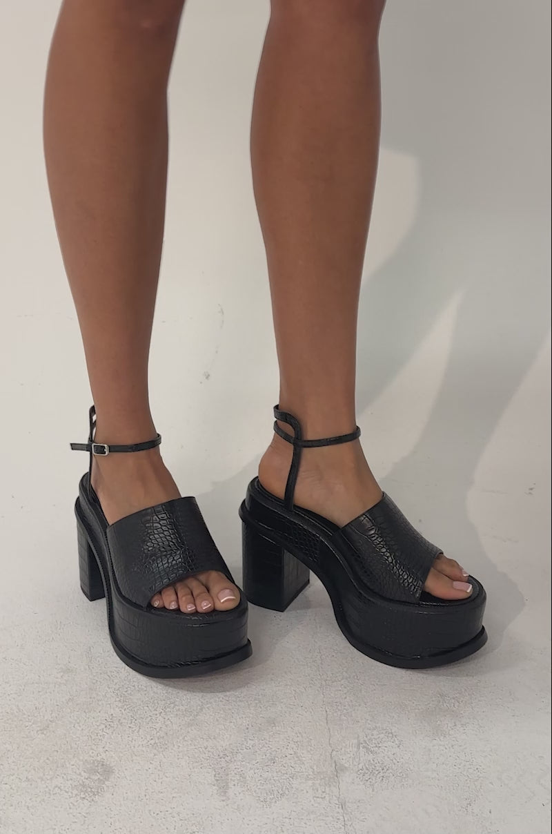 A video of a person wearing the AZALEA WANG ANTHELMINE BLACK CROC PLATFORM SANDAL.
