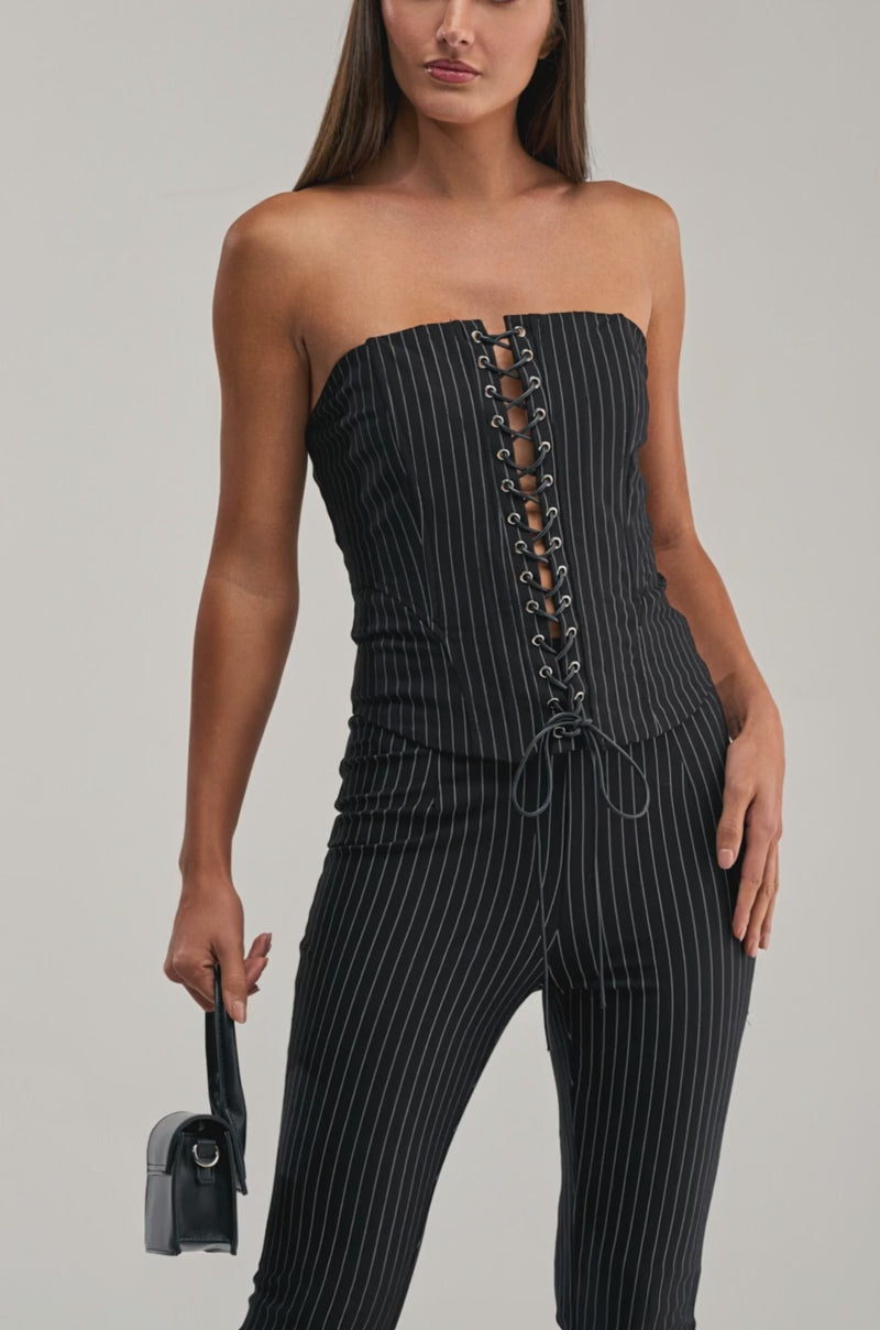 Video of woman modeling the LIVI STRETCHY PINSTRIPE CORSET with matching pinstriped pants and a small black handbag, standing against a plain light gray background.