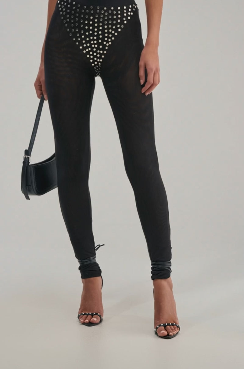 A video of a person wearing the COOLEST GIRL ON THE BLOCK MESH LEGGING WITH STUDS—sheer black mesh with silver studs in a triangular pattern.