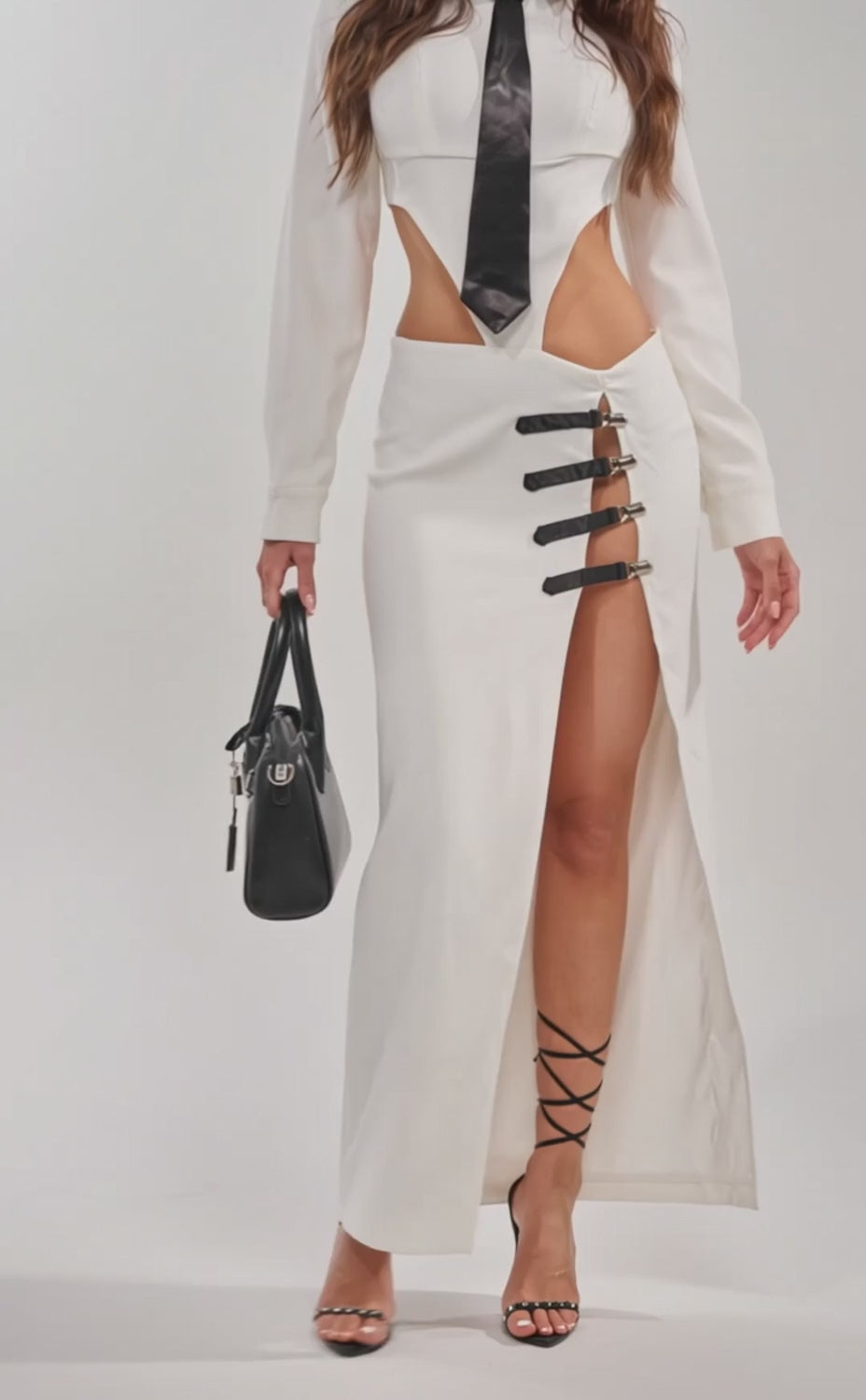 Video of woman modeling the MAKE A STATEMENT ONE SHOULDER MIDI DRESS with black strappy heels, sunglasses, and a black handbag.