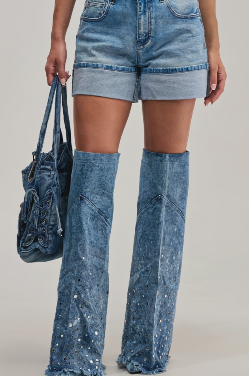 Video of a woman modeling the CARLY DENIM SHORT, featuring a cuffed hem and high-rise wais.