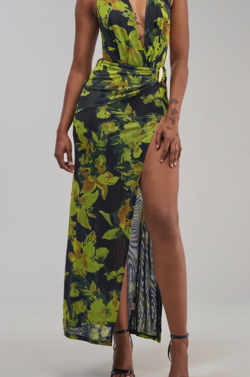 Video of a woman modeling the PLUS ONE FLORAL MESH MAXI DRESS IN BLACK MULTI—a sleeveless maxi dress featuring a deep v-neckline, black and green floral print, high slit.