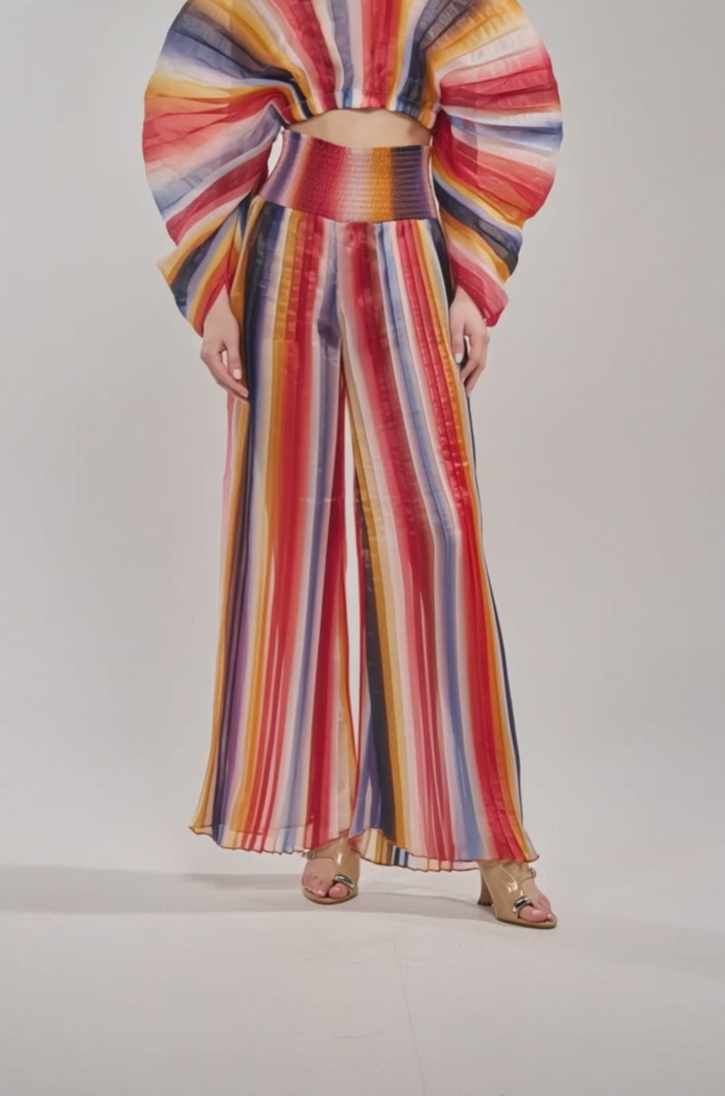 Video of woman modeling the FANNED OUT CHIFFON PANT—multicolor striped wide-leg pants with vertical red, yellow, blue, and white stripes