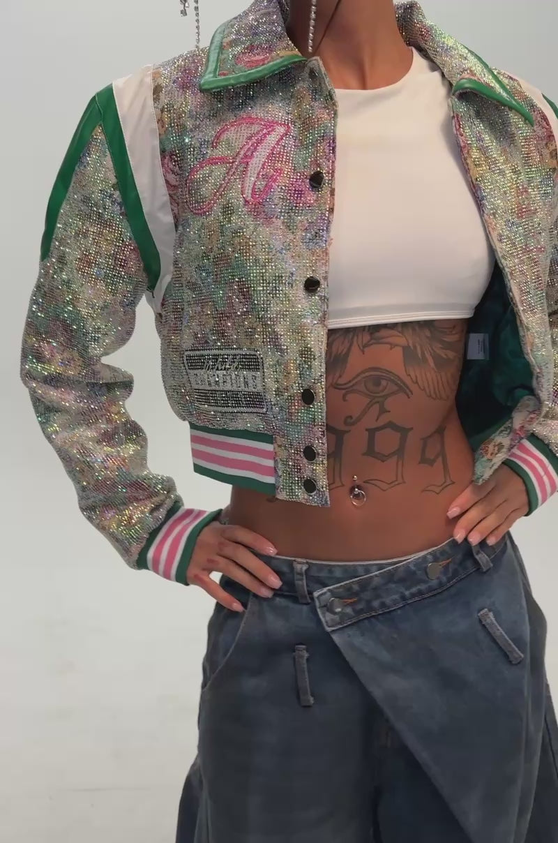 Video of a woman modeling the TAPPED OUT RHINESTONE BOMBER, adorned with sparkling florals, striped cuffs and collar.