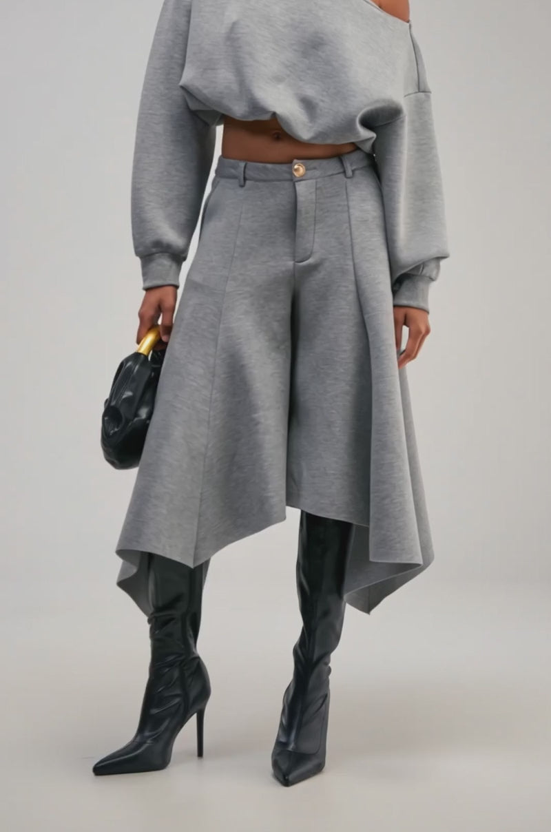 Video of a woman modeling the WILD AND FREE CULOTTES in grey with a wide, draped silhouette and high-rise waistband.