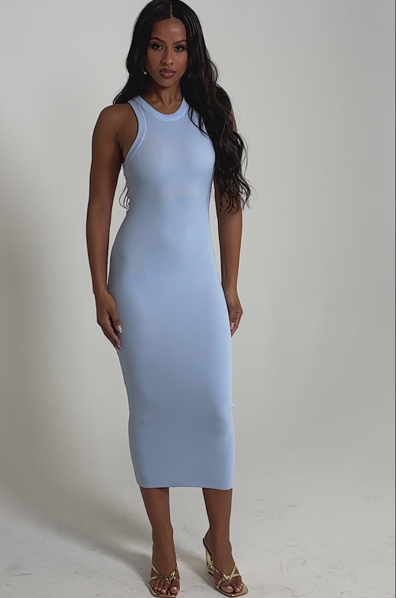 Video of woman modeling the CUTIE PIE KNIT MIDI DRESS IN LIGHT BLUE and gold open-toe heels, standing against a plain light background.
