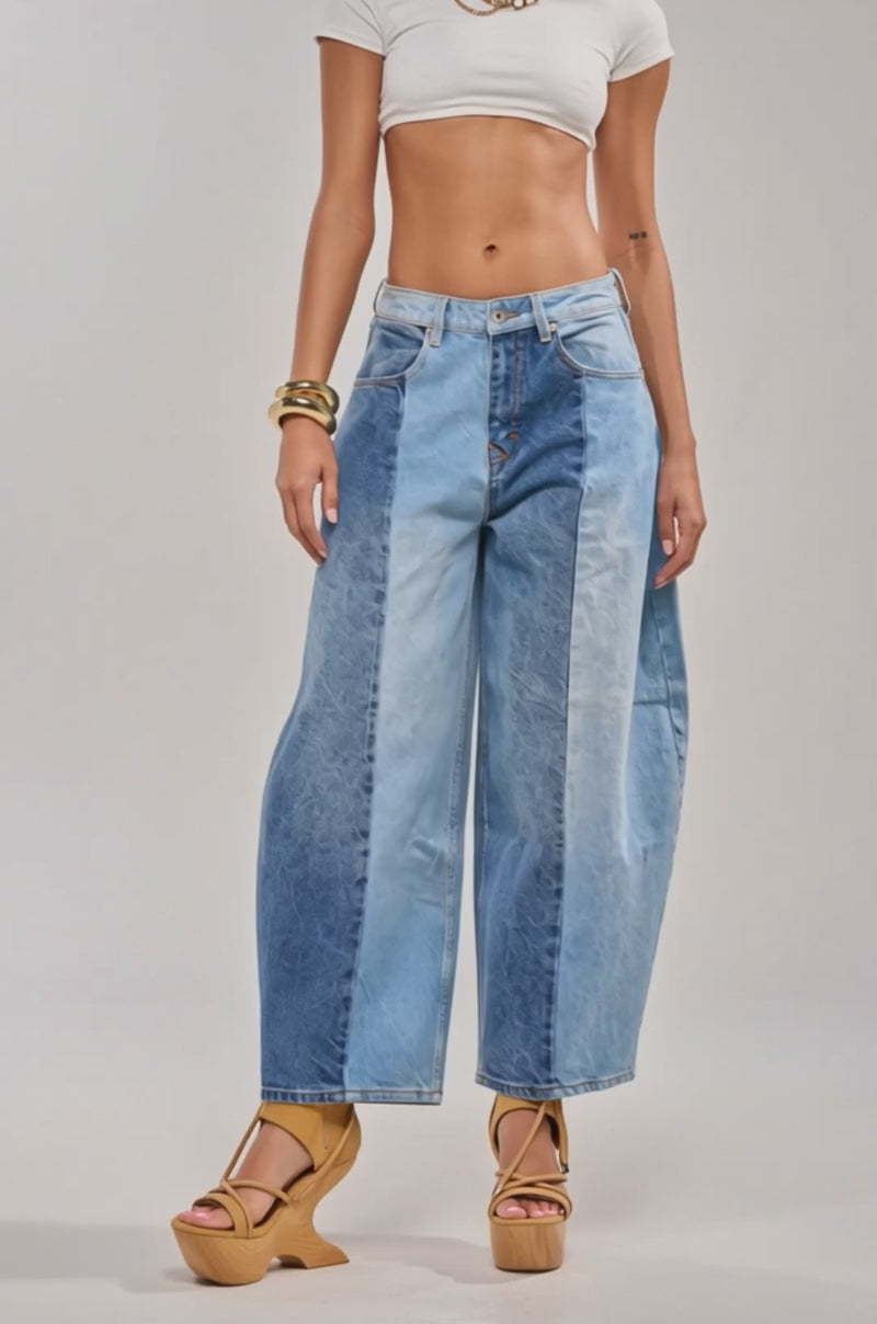 Video of woman modeling the MIXED EMOTIONS COLORBLOCKED BARREL DENIM in blue shades, paired with tan platform heels and gold bracelets