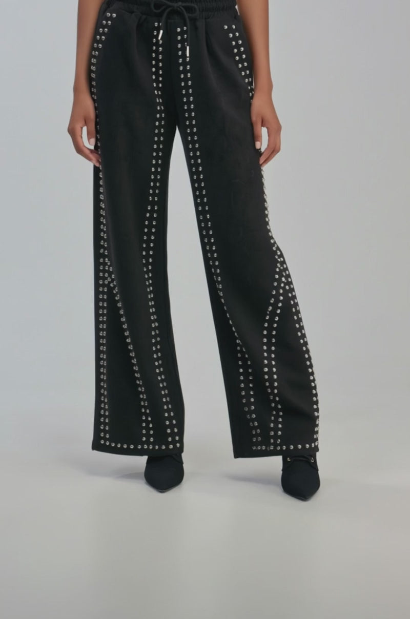 Video of a woman modeling the ASHLEY STUDDED WIDE LEG JOGGER, featuring silver studs in vertical lines.