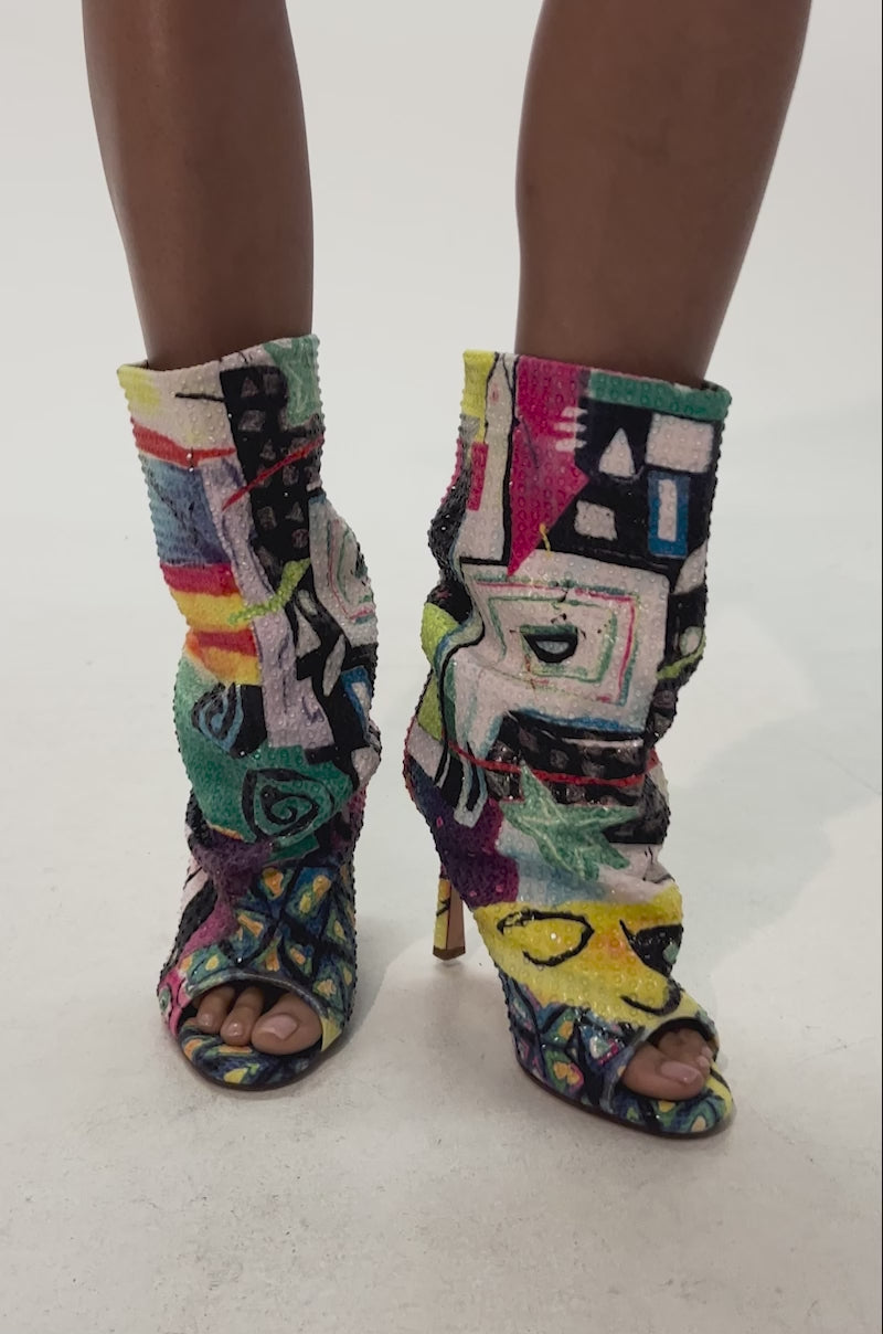 Video of woman modeling the AZALEA WANG JONICE MULTI OPEN TOE BOOTIE—a statement boot covered in colorful, abstract-patterned sequins with a slouchy fit.