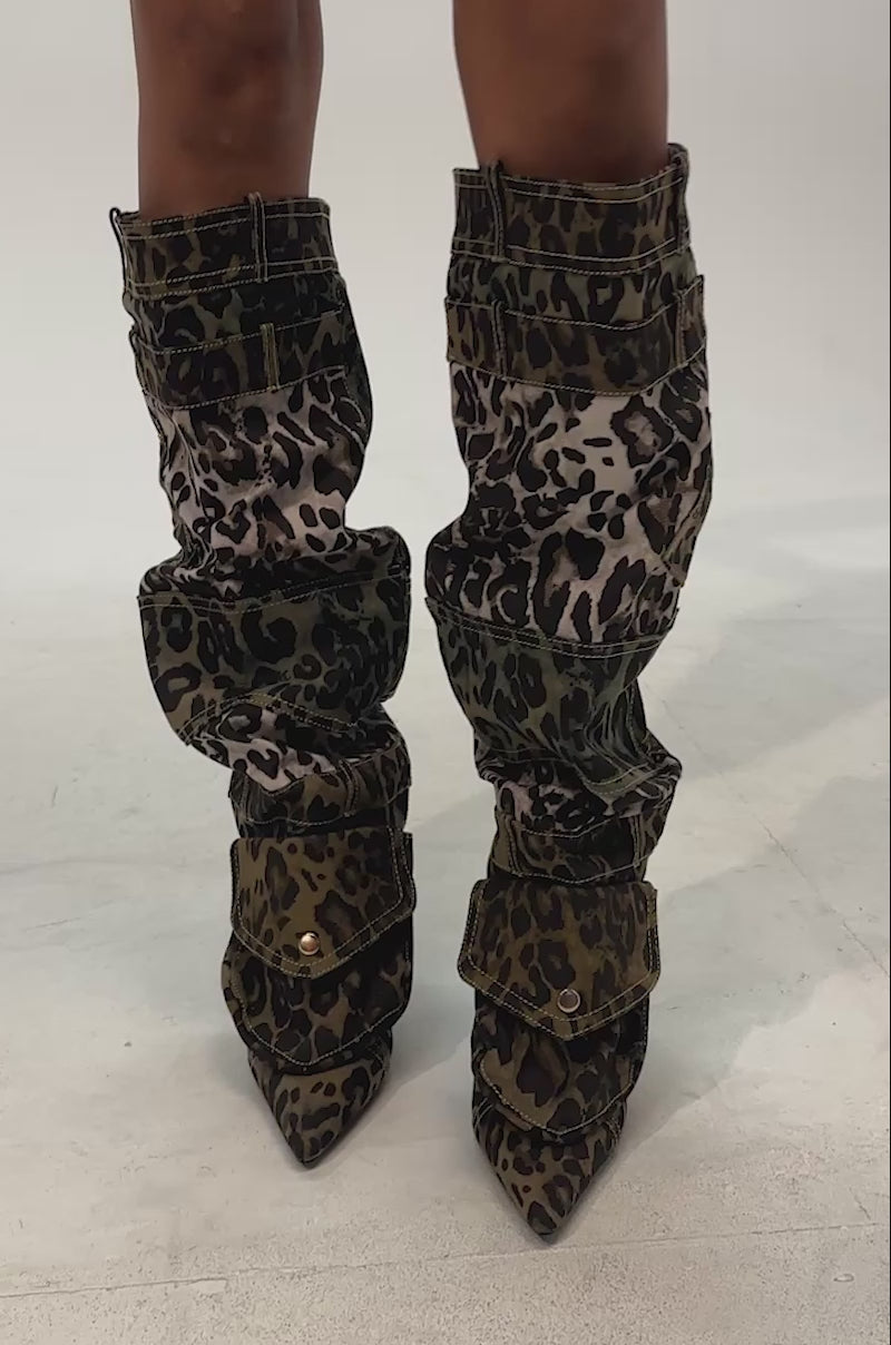 Video of woman modeling the AKIRA GOLD HALOISE LEOPARD POCKET DETAIL STILETTO BOOT, which features a striking green and brown leopard print
