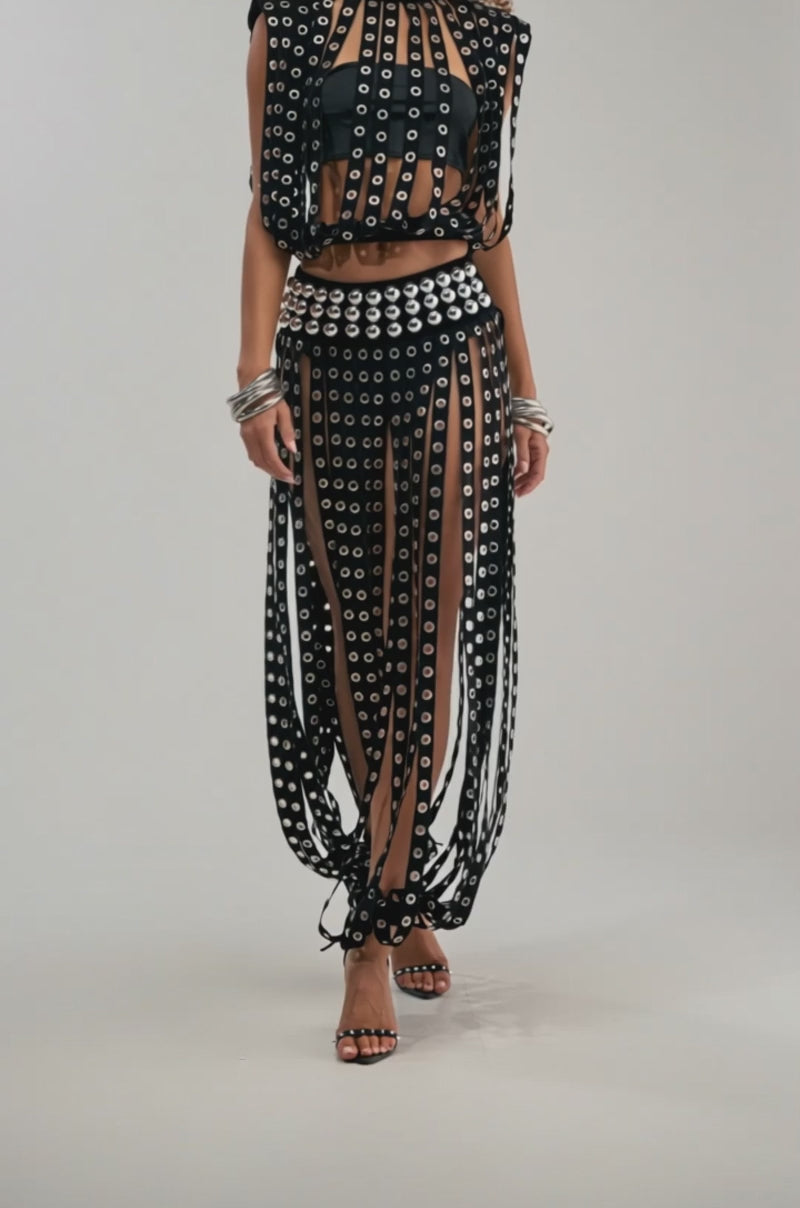 A video of a woman wearing TOUCH IT GROMMET JOGGER features rocker chic style with black sheer panels, vertical strips, and a matching waistband.