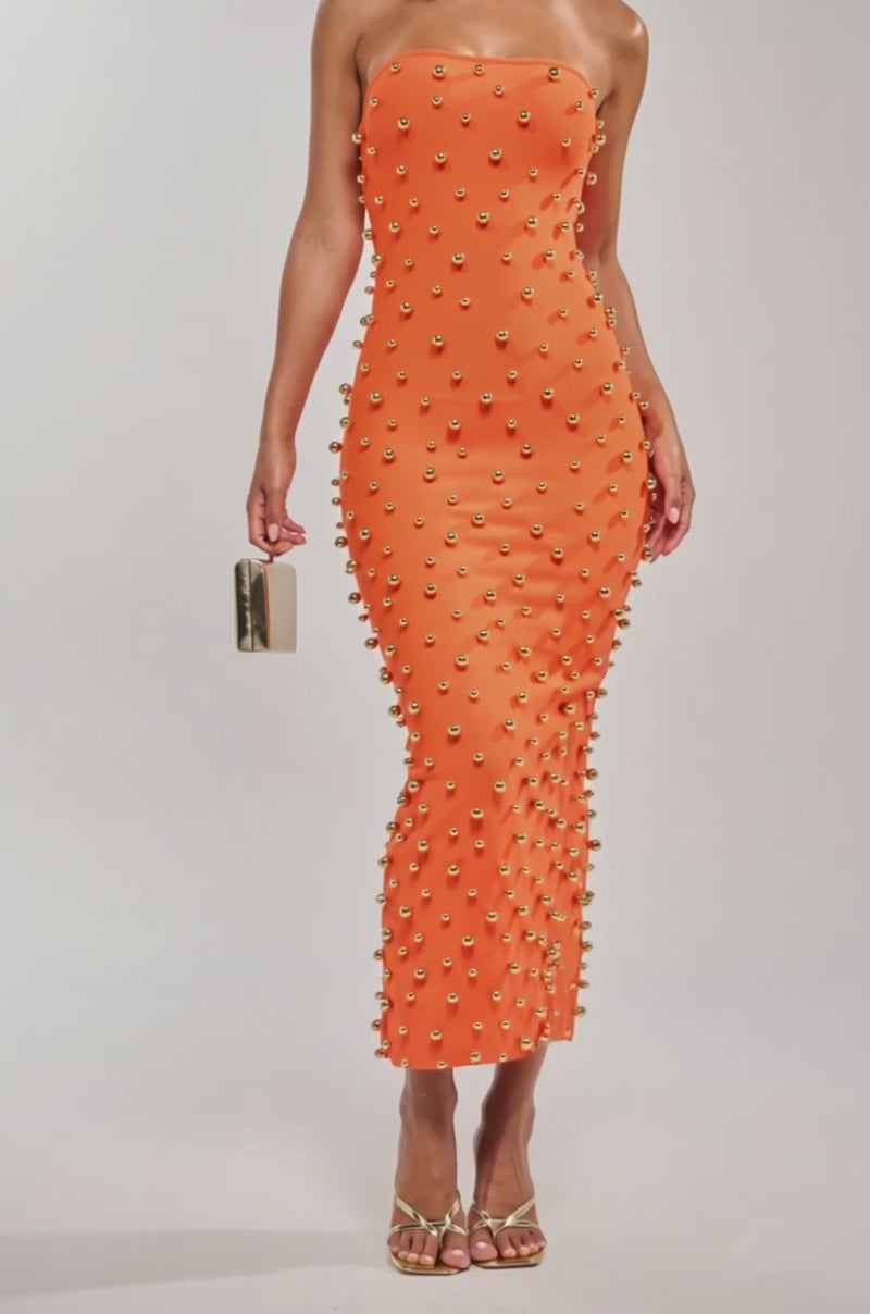 Video of woman modeling the SERVING LOOKS STRAPLESS STUDDED MIDI DRESS with gold hoop earrings and sandals, holding a metallic clutch. Her sleek ponytail completes this stunning event-ready outfit.