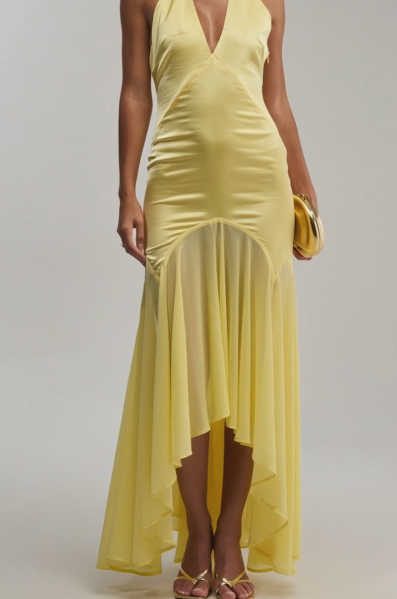 A video of a woman wearing the "BET YOU WON'T Satin Midi Dress in Yellow," featuring a butter-yellow hue, halter neckline, deep V-neck, and high-low hem.