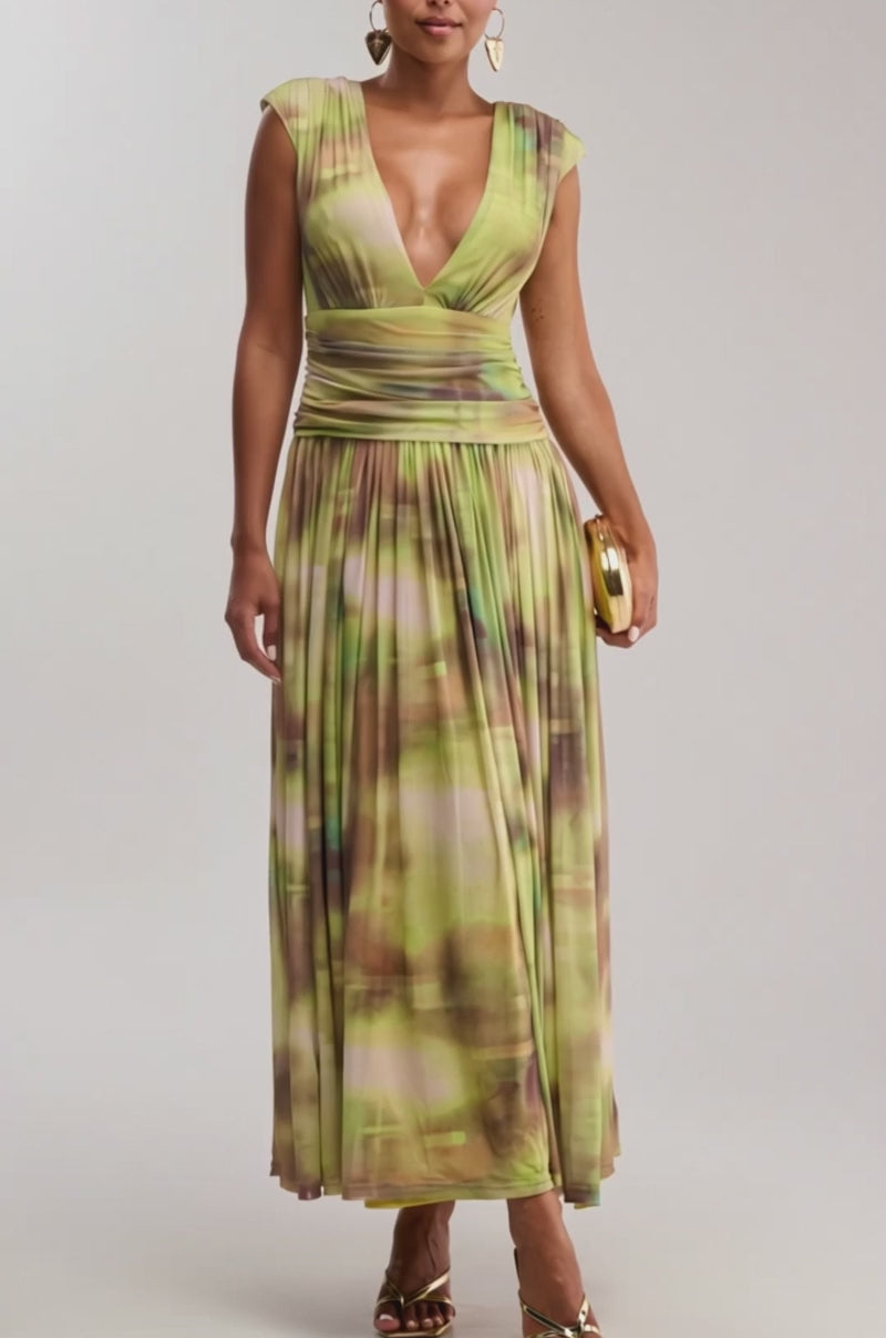 Video of woman modeling the TEA TIME ABSTRACT MAXI DRESS IN GREEN with cap sleeves, deep V-neckline, gold sandals, heart-shaped earrings, and a small gold clutch—a perfect summer date night look.