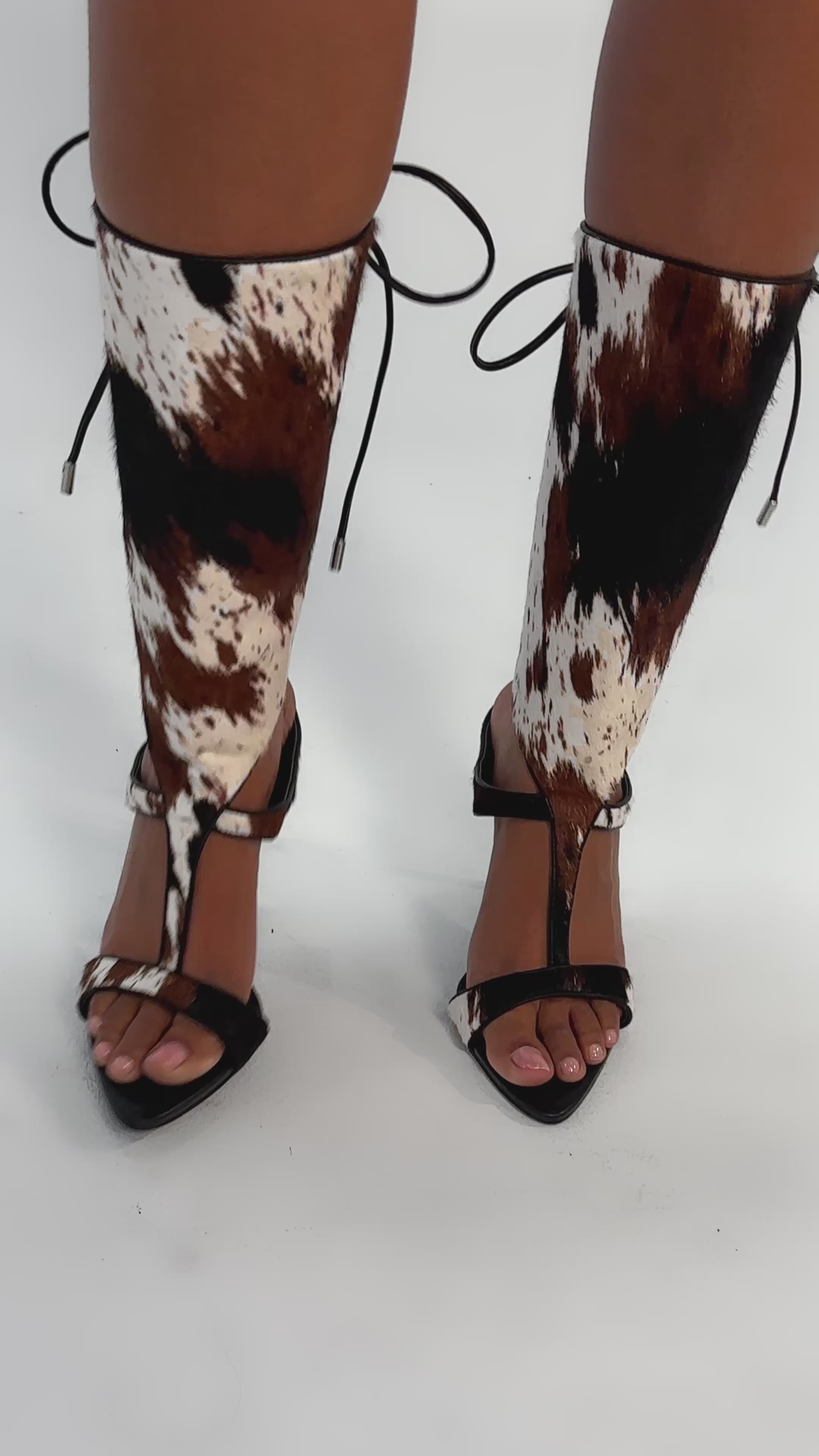 Video of woman modeling AKIRA GOLD CALF HAIR LACE UP GLADIATOR STILETTO SANDAL with black lace-up calf coverings