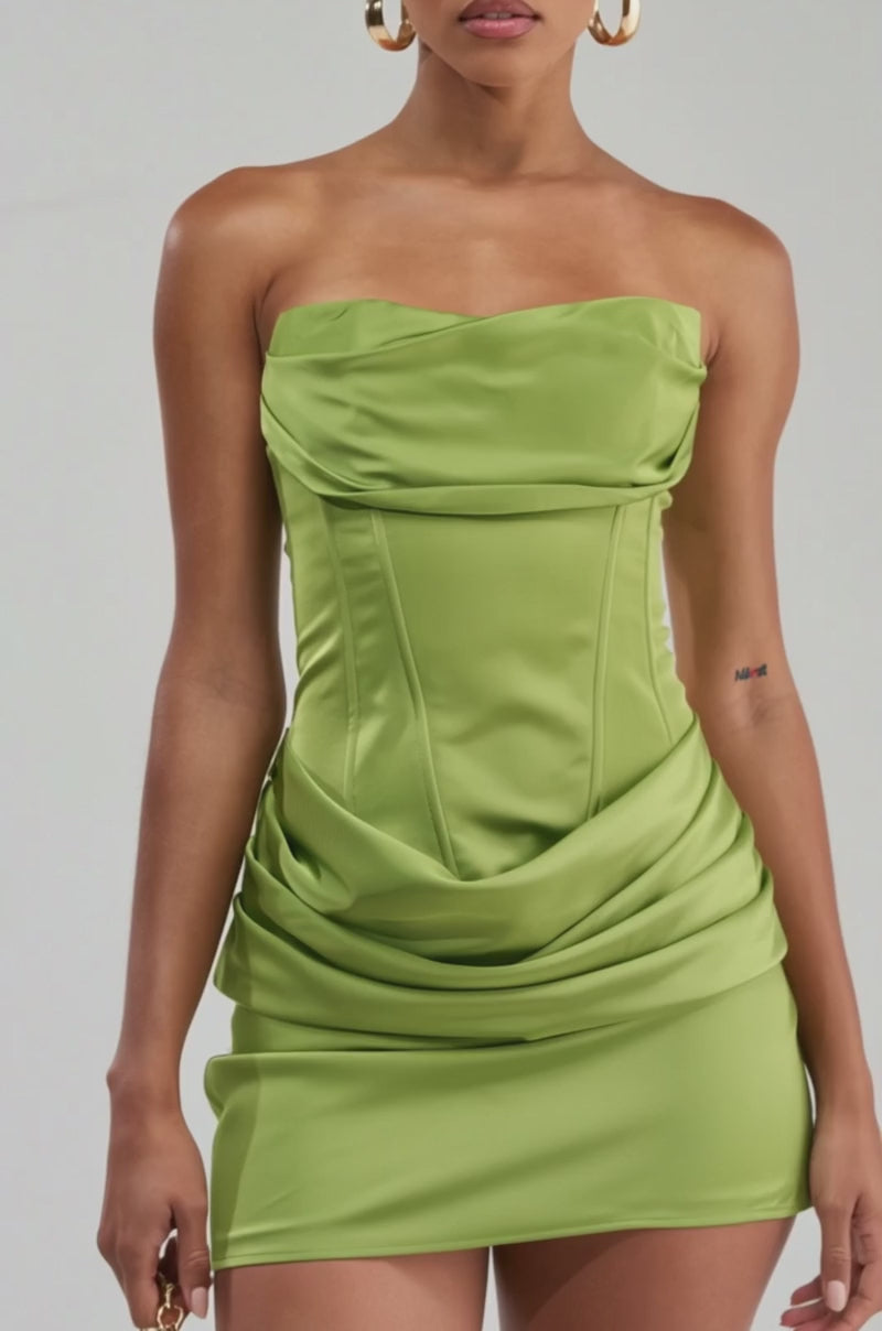Video of a woman modeling the NO COMPETITION STRAPLESS SATIN MINI DRESS IN CHARTREUSE— a fitted mini with draped details and structured bodice.