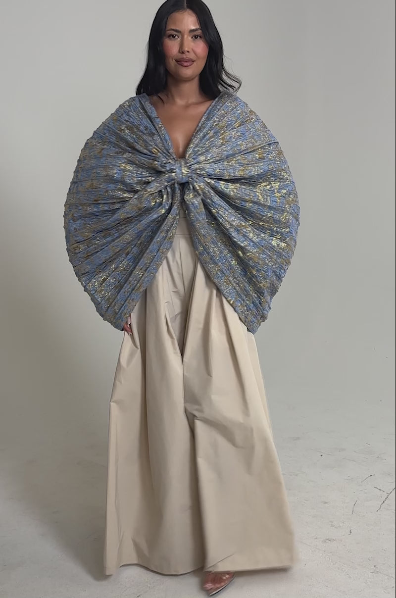 Video of woman modeling the GLORY BROCADE BLOUSE, a blue metallic piece with a statement bow