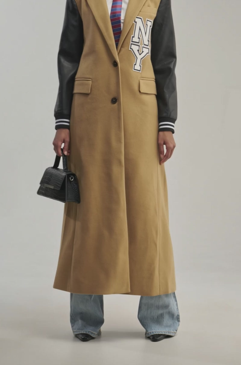 Video of a woman modeling the BRENTWOOD 2.0 VARSITY TRENCH—a tan trench coat with faux leather sleeves and an “NY” patch.