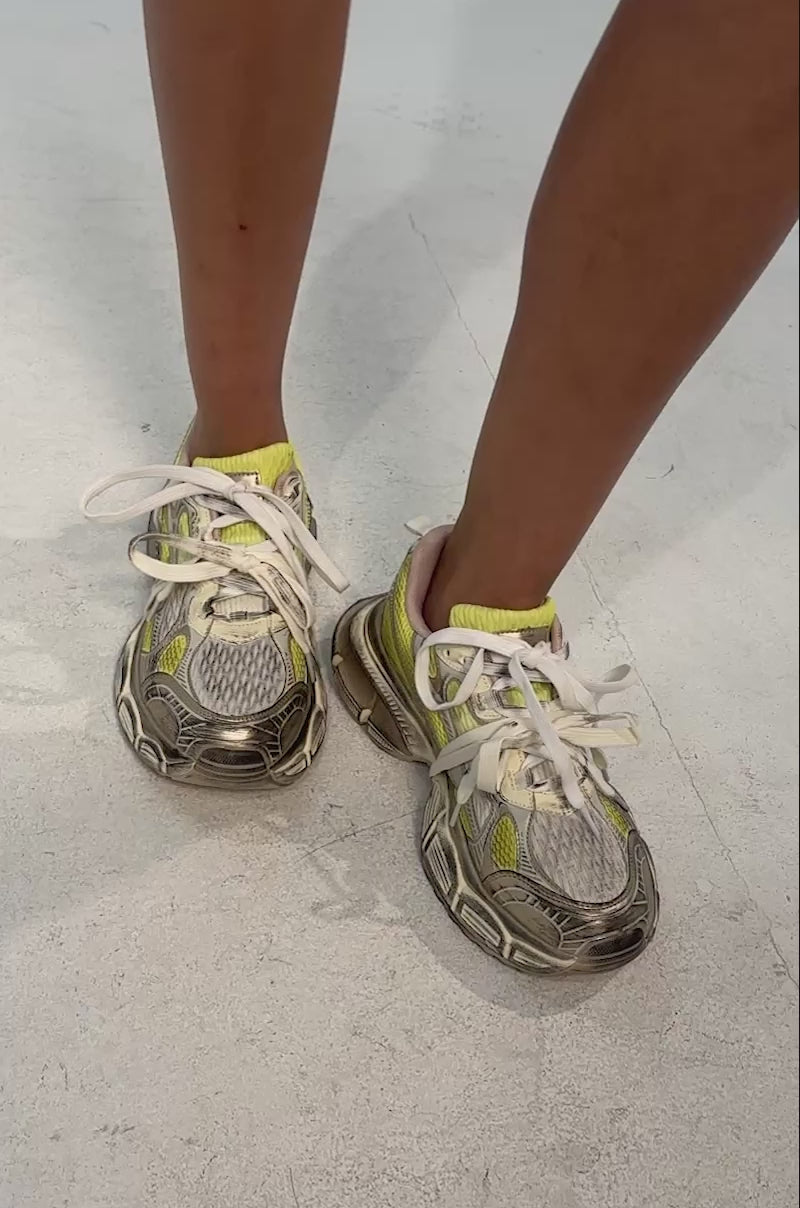 Video of woman modeling the AKIRA GOLD CALU CITRON YELLOW SNEAKER with a chunky platform sole and untied laces