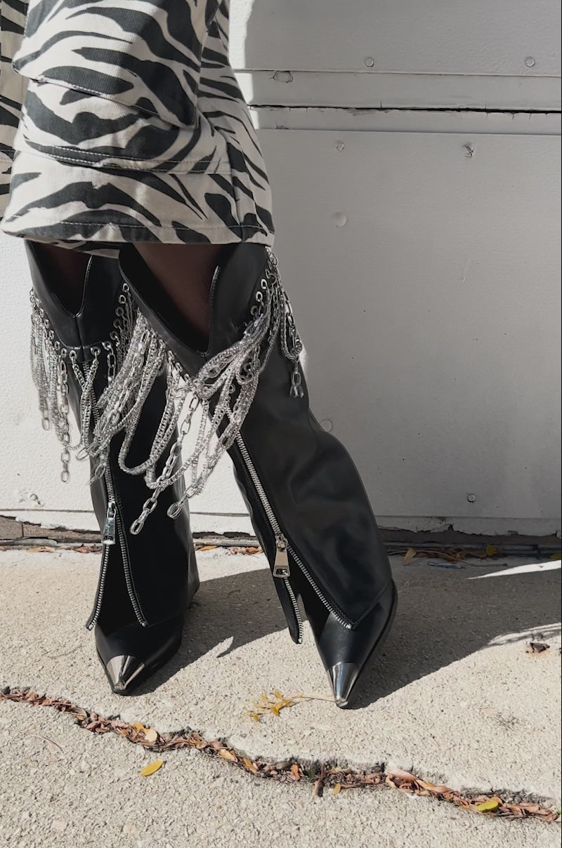 Video of woman modeling the AZALEA WANG SINISTER BLACK WESTERN CHUNKY BOOTS decorated with silver chains.