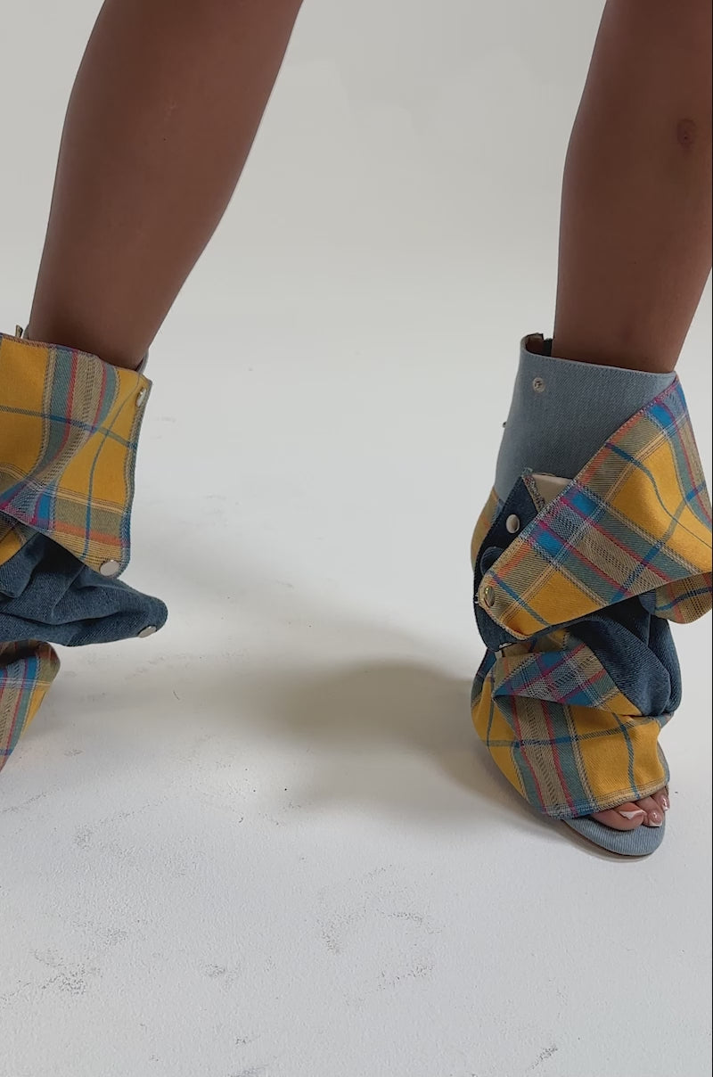 A video of a person wearing a short flared denim skirt and the AZALEA WANG BIRDSONG YELLOW PLAID SNAP BOOTIE.