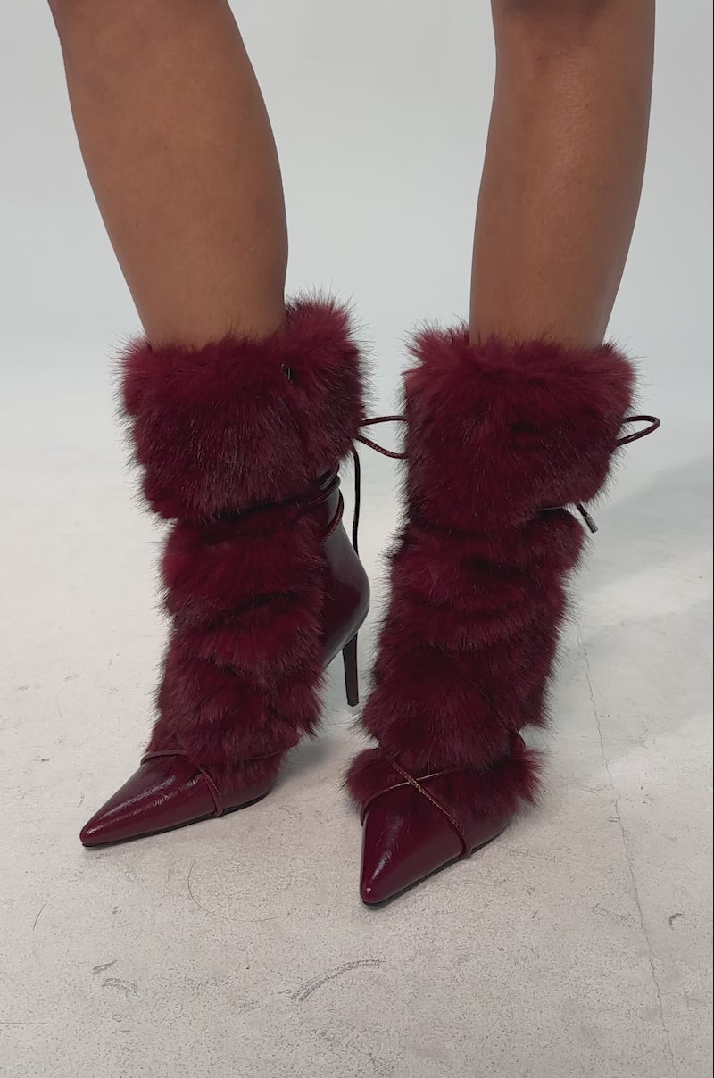 A video of a model wearing the Azalea Wang MAHTAMA-BURGUNDY bootie. It features burgundy fur and a tie-up detail.