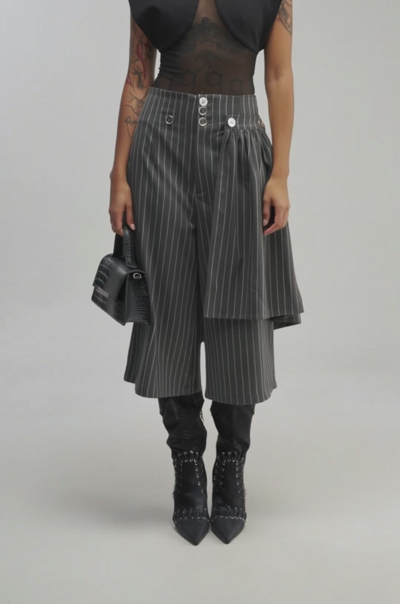 Video of a woman modeling the OFFICE SIREN STRIPED GUACHO PANT, featuring a removable pleated skirt.