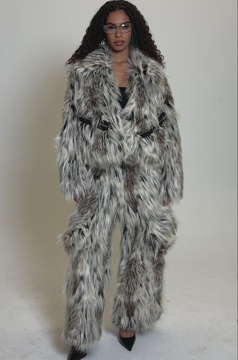 Video of woman modeling the PARTICULAR TASTE FAUX FUR CARGO PANTS paired with an oversized shaggy faux fur jacket in cream, brown, and black.