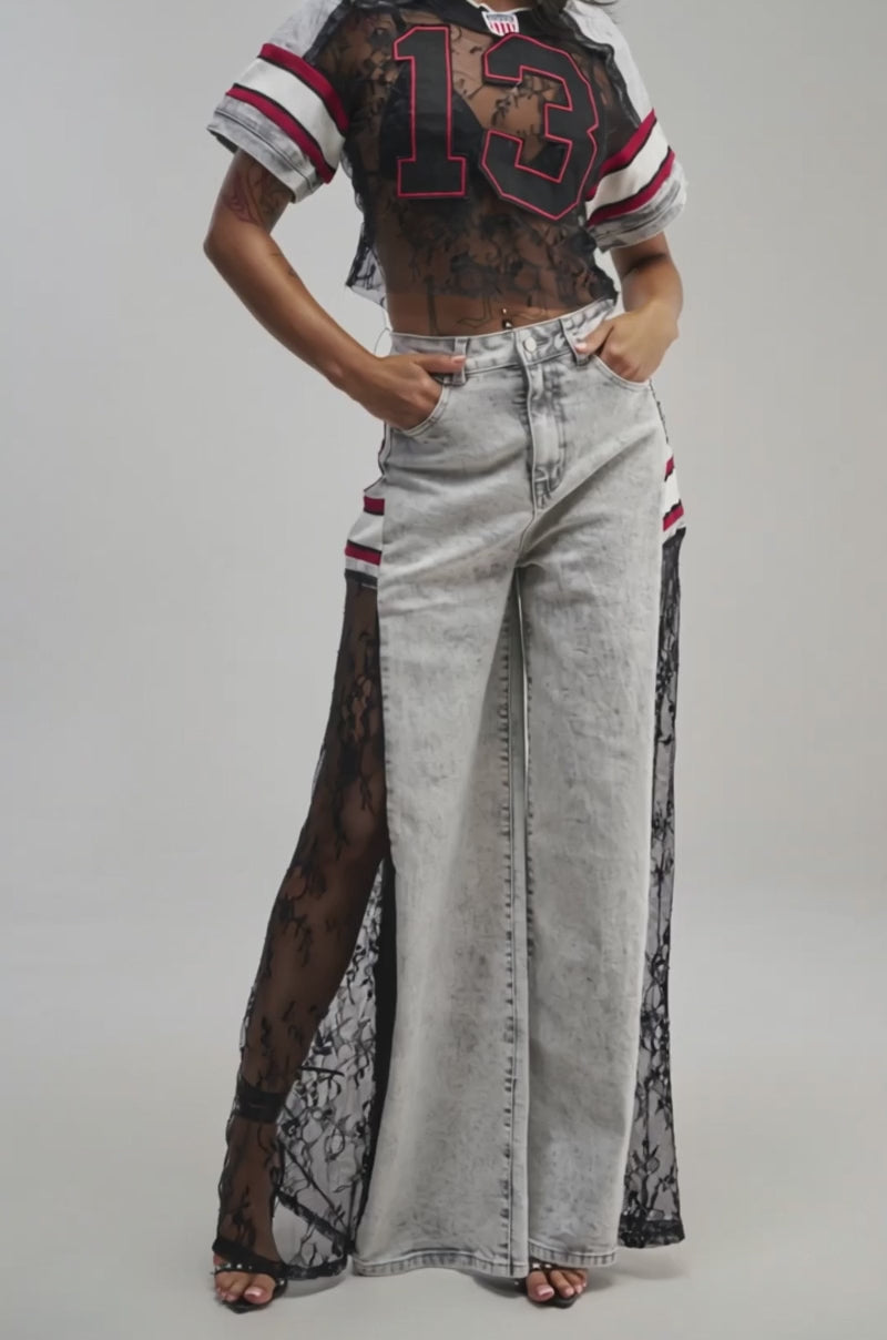 Video of a woman modeling the VARSITY SQUAD JERSEY—a black lace varsity crop top featuring the number 13.