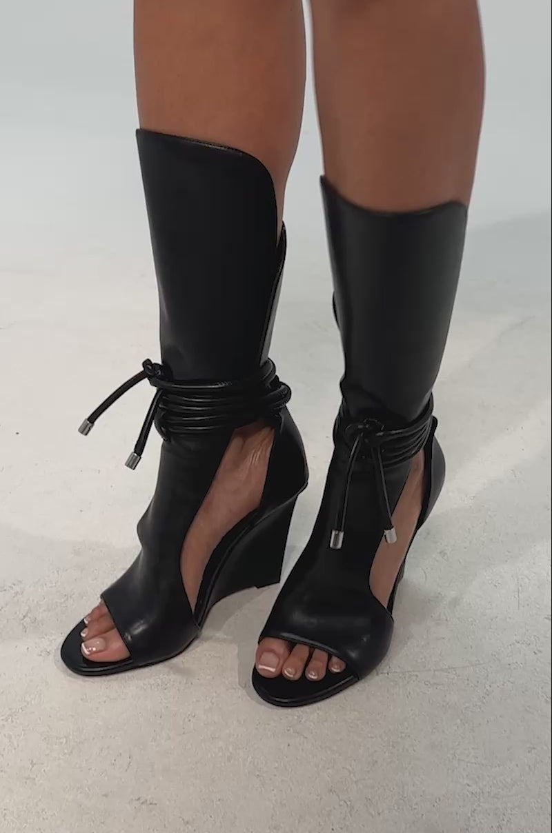 Video of woman modeling the AZALEA WANG DOUMA Black Wedge Lace Up Tall Shaft Sandals.