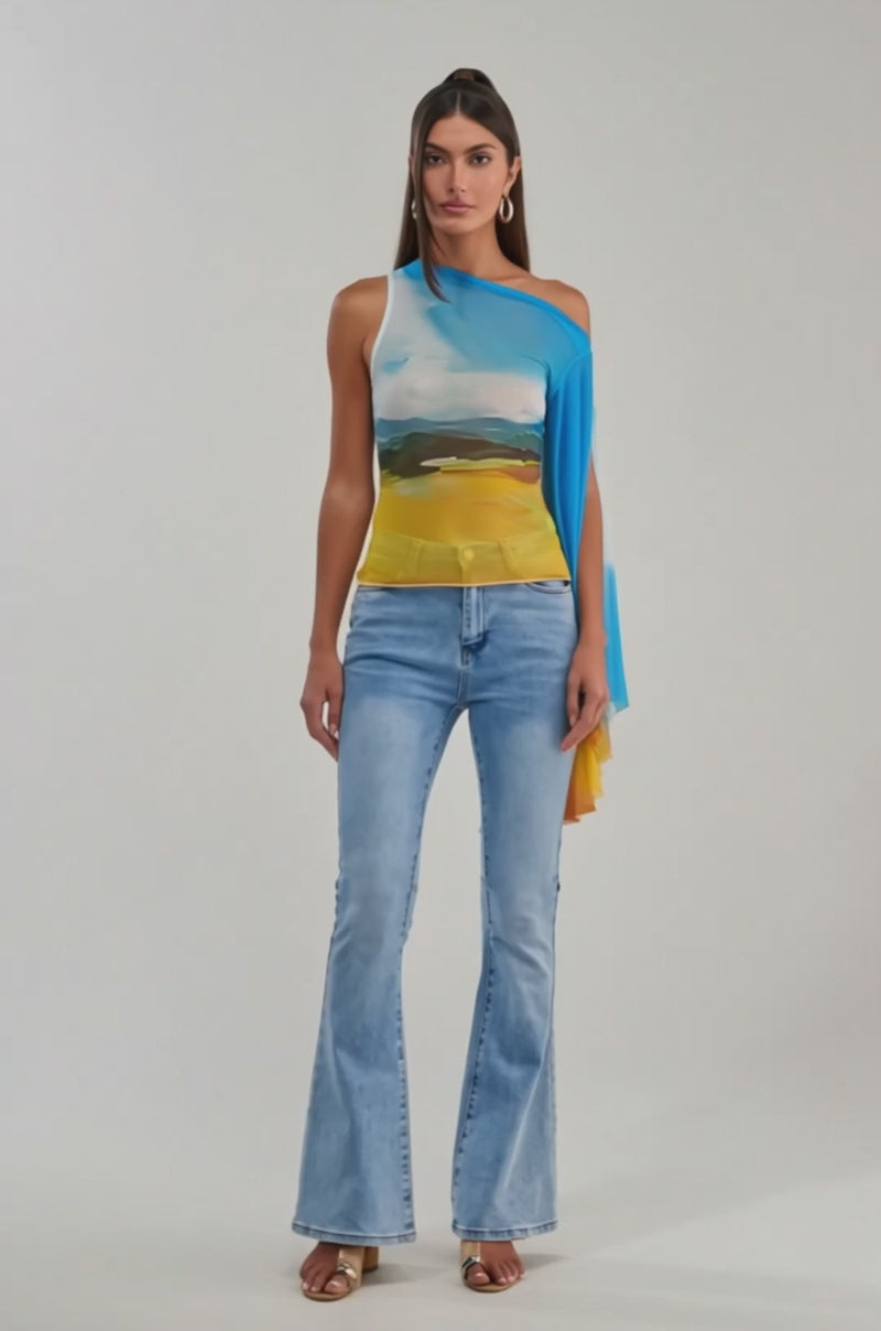 Video of woman modeling the PICTURESQUE LONG SLEEVE MESH TOP in blue, white, and yellow sky print with light blue jeans.